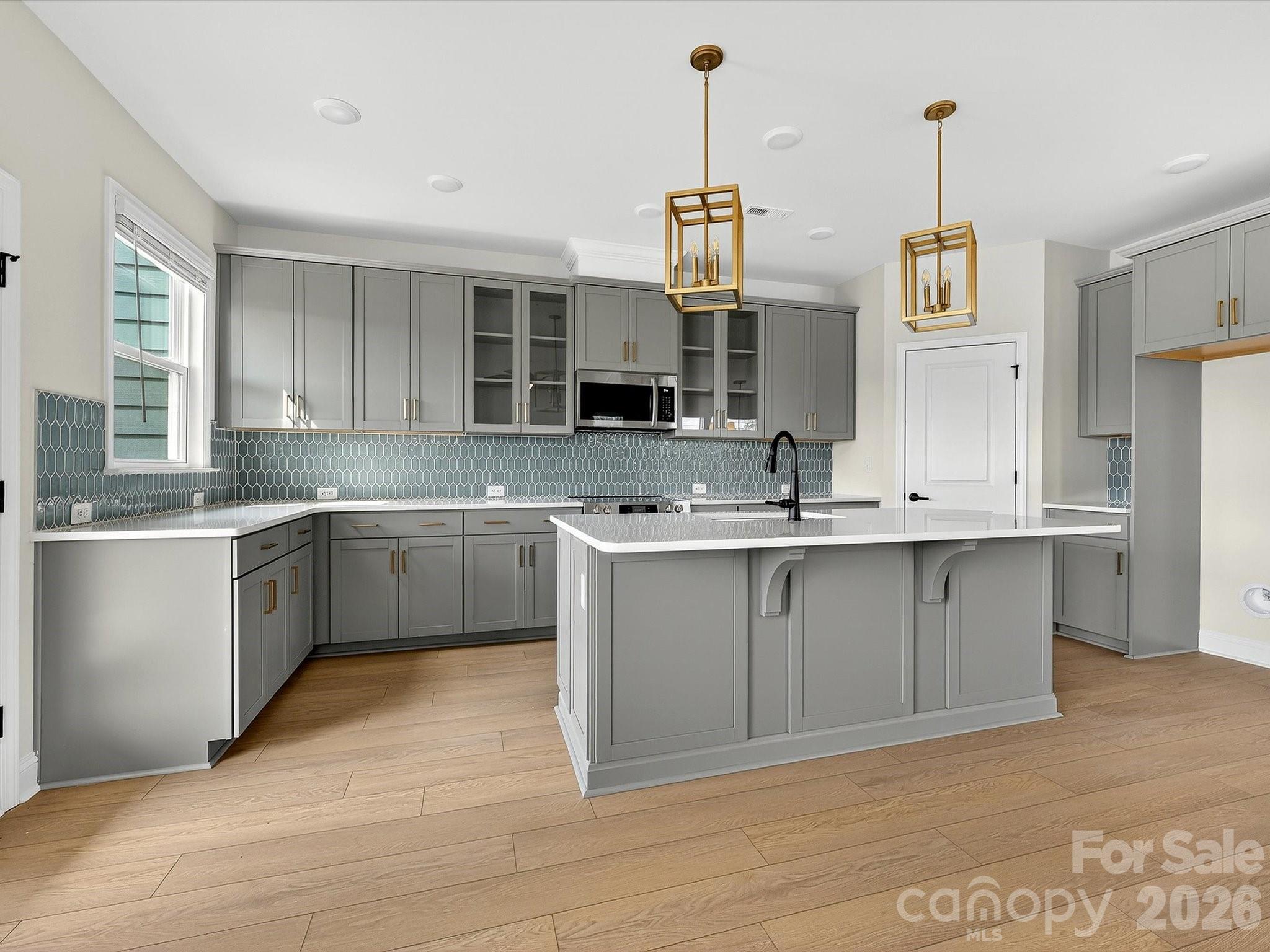 42" cabinets with soft close doors and drawers, quartz countertops, tile backsplash. Frigidaire gallery appliances. Microwave is exhaust vented to the outside. Large pantry with solid shelving - 218 Quartz Hill Way, Waxhaw