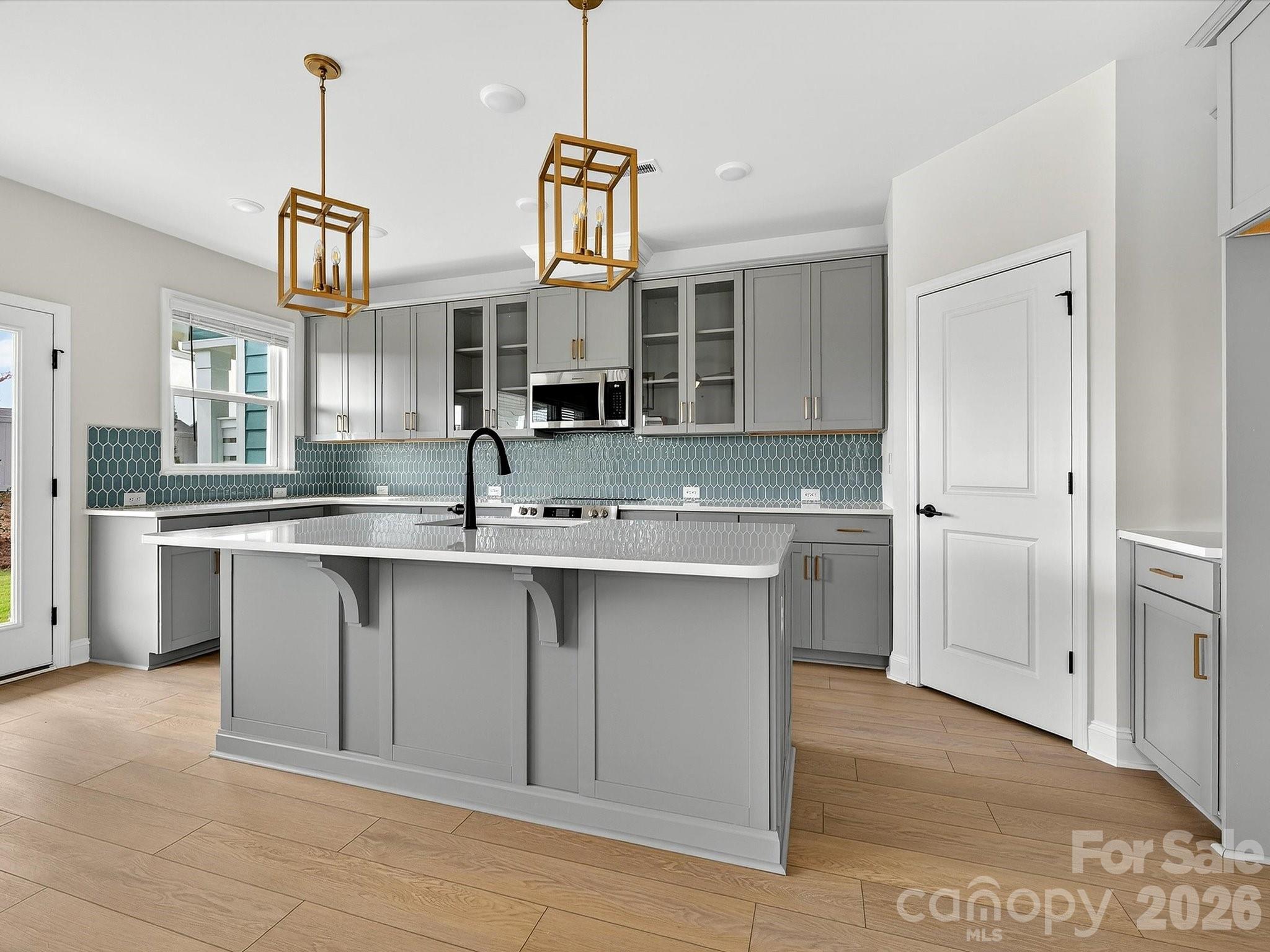 42" cabinets with soft close doors and drawers, quartz countertops, tile backsplash. Frigidaire gallery appliances. Microwave is exhaust vented to the outside. Large pantry with solid shelving - 218 Quartz Hill Way, Waxhaw