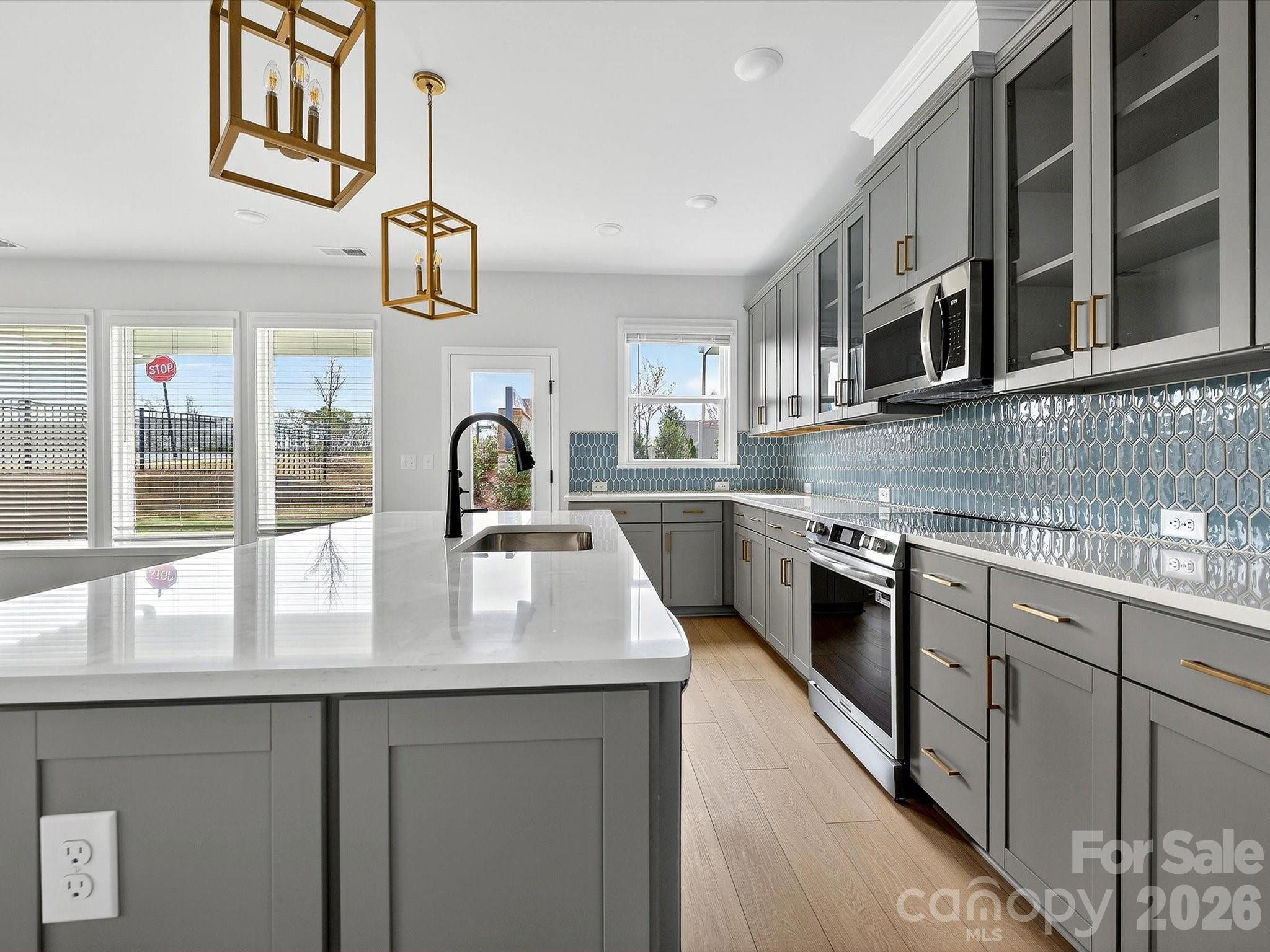 42" cabinets with soft close doors and drawers, quartz countertops, tile backsplash. Frigidaire gallery appliances. Microwave is exhaust vented to the outside. Large pantry with solid shelving - 218 Quartz Hill Way, Waxhaw