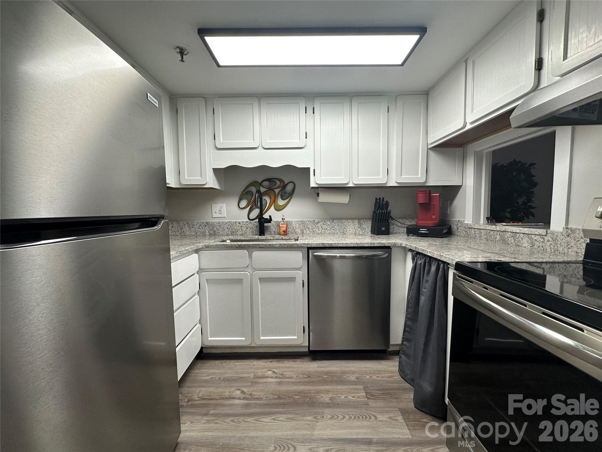 Enjoy a beautifully updated kitchen with sleek granite countertops and modern stainless steel appliances - 315 Spruce Street N, Winston Salem