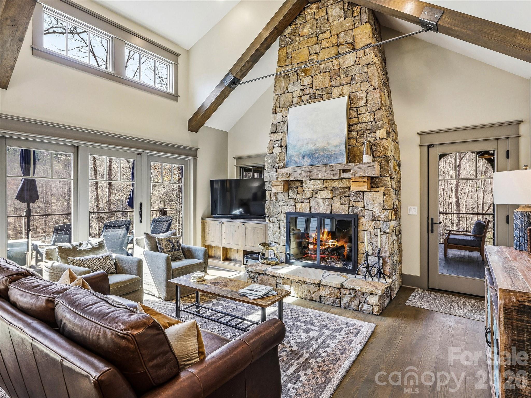 Stacked stone wood burning fireplace with a gas log system installed. Easy access to the screened porch to the right. - 3735 French Broad Parkway, Marshall