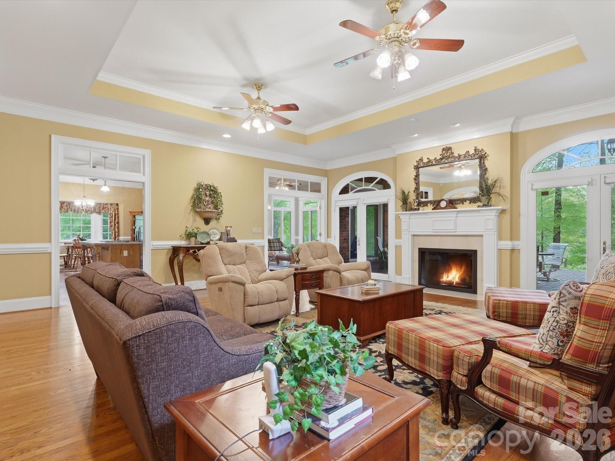 Family Room/ Den. Kitchen and Four Seasons Room entrances as well as two sets of double french doors to brick patio. Fireplace. Tray ceilings, transom windows, arched doorways to exterior carrying the decor of the arched entryway look. - 1215 Rosa Drive, Monroe