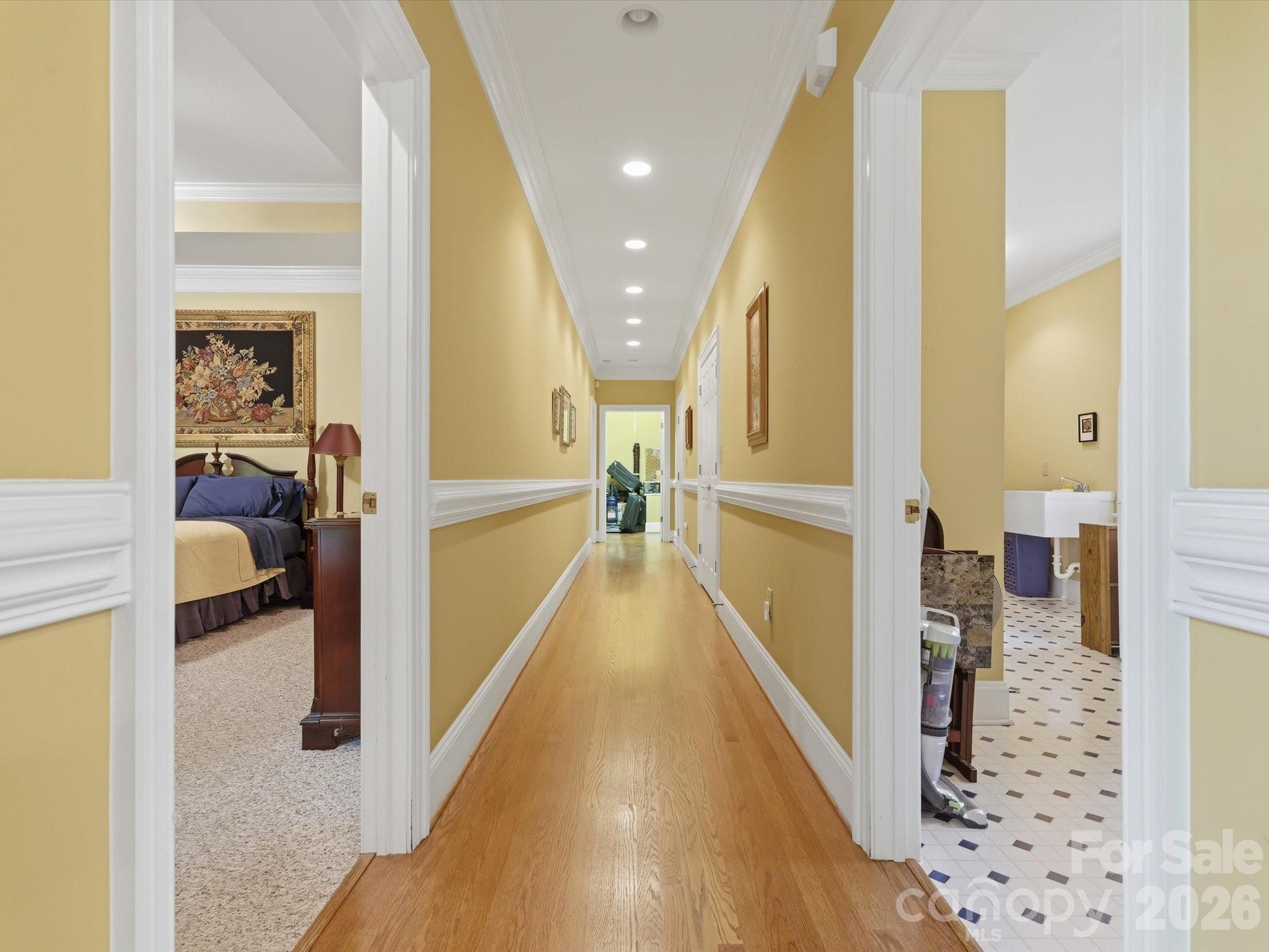 Hallway to primary (left) and laundry room (right). End of hallway storage with pull down stairs- originally designed for full staircase with access to additional space to build out a bonus space on upper level. - 1215 Rosa Drive, Monroe