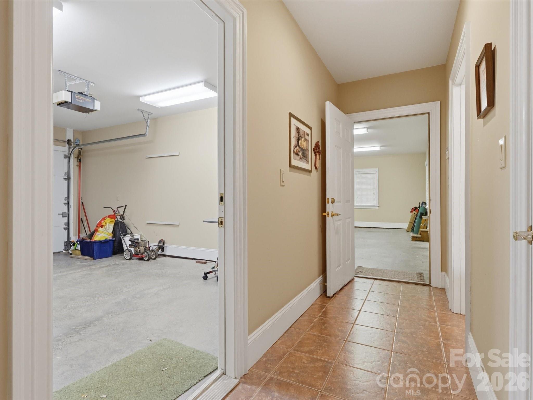 Hallway to garage spaces. Single garage is heated/cooled. Half bath on right and additional storage closet right side. - 1215 Rosa Drive, Monroe
