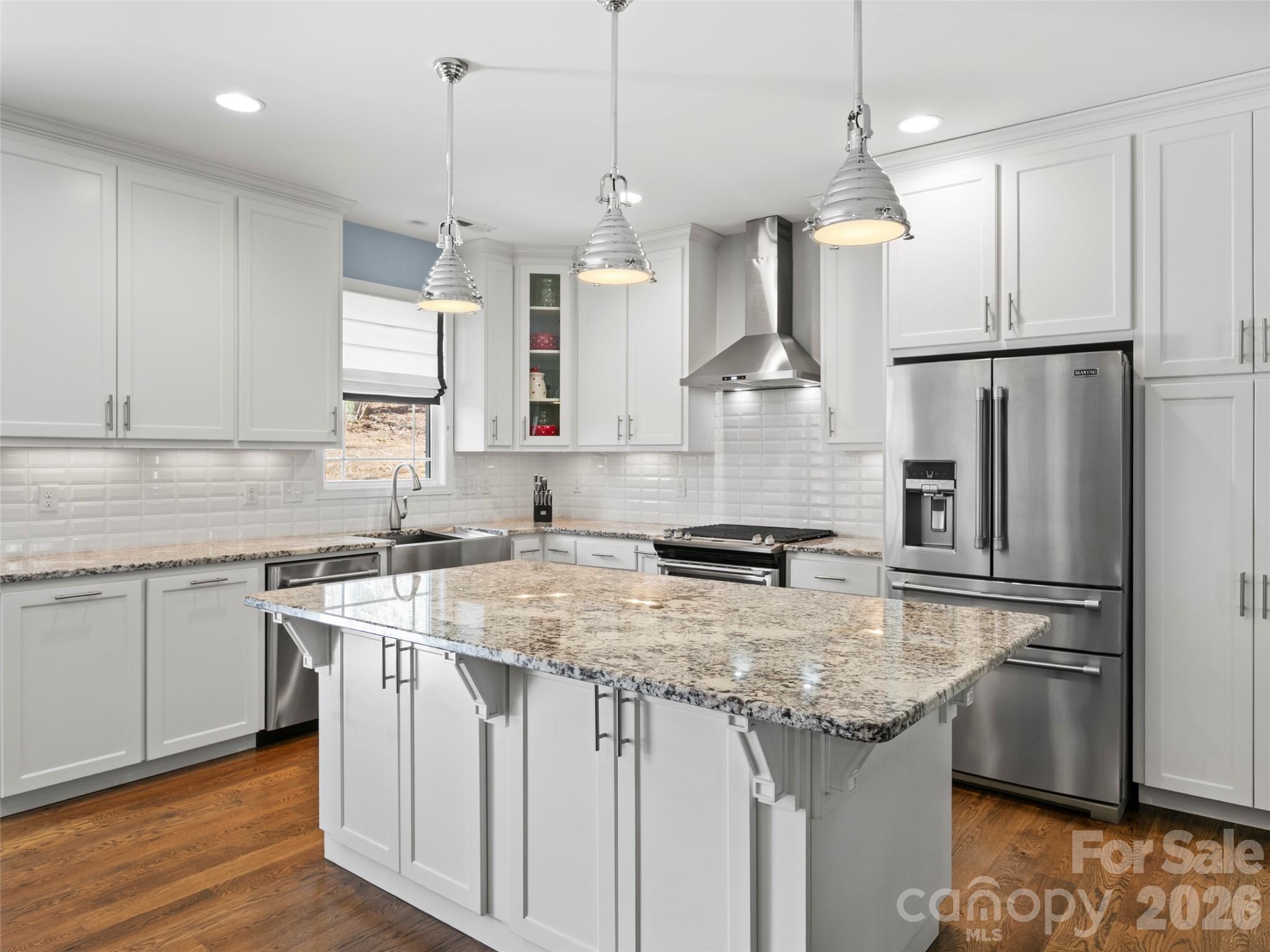 Open-concept kitchen featuring custom cabinetry, stainless steel appliances, and a spacious island ideal for entertaining or meal preparation - 290 Sweetwater Hills Drive, Hendersonville