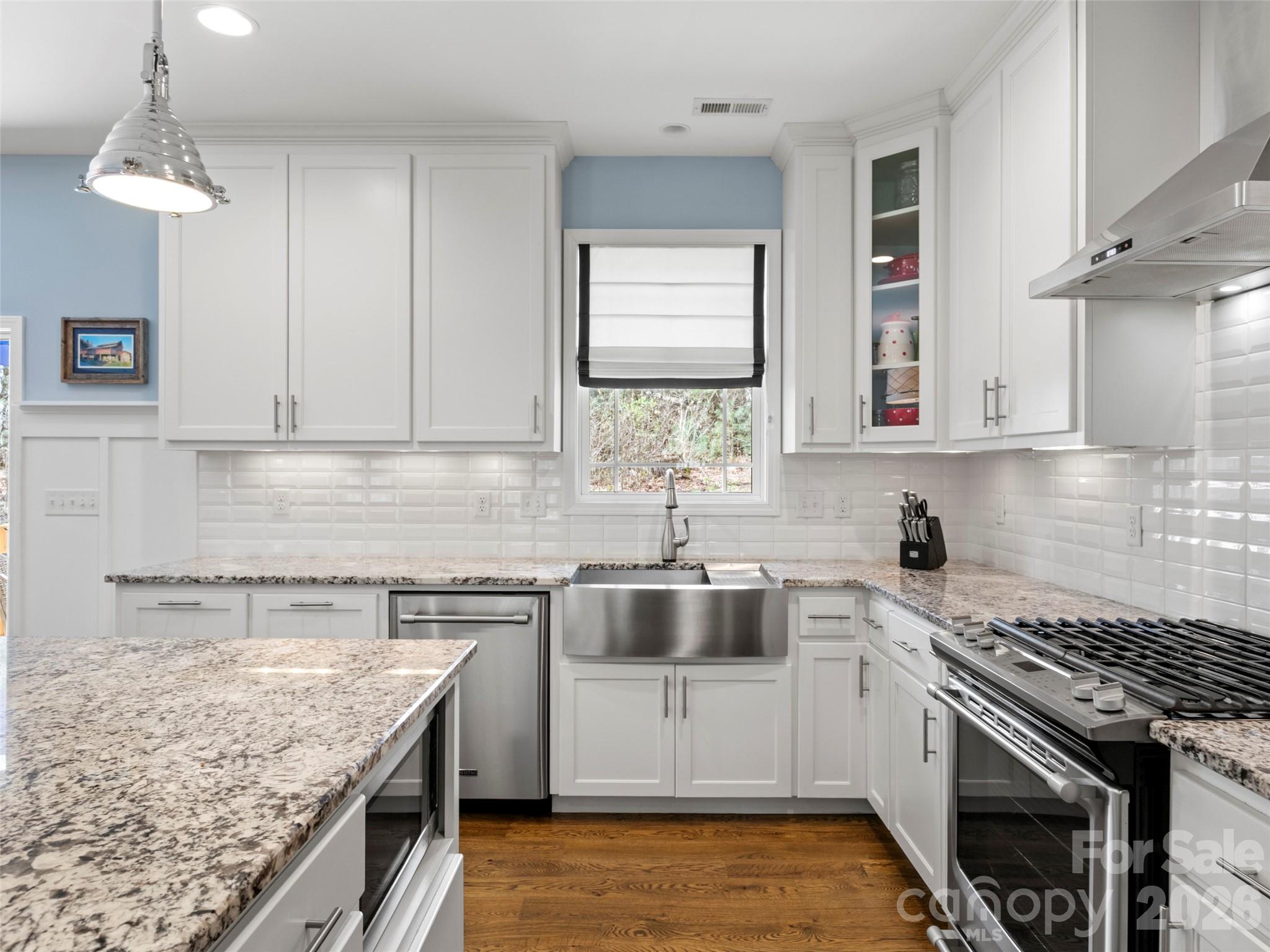 Well-appointed kitchen with custom cabinets, sleek stainless steel appliances, and a large island designed for gathering and everyday functionality - 290 Sweetwater Hills Drive, Hendersonville