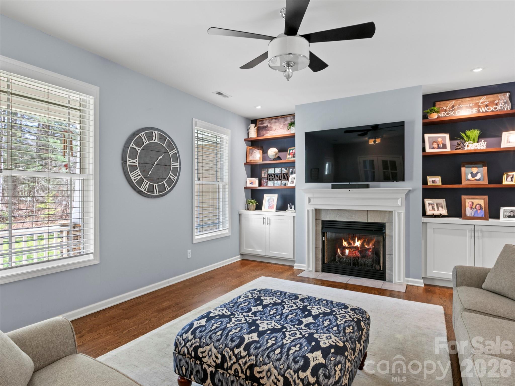 Bright and open main-level living space designed for comfort and connection, enhanced by custom built-in shelving that provides refined detail and practical organization - 290 Sweetwater Hills Drive, Hendersonville