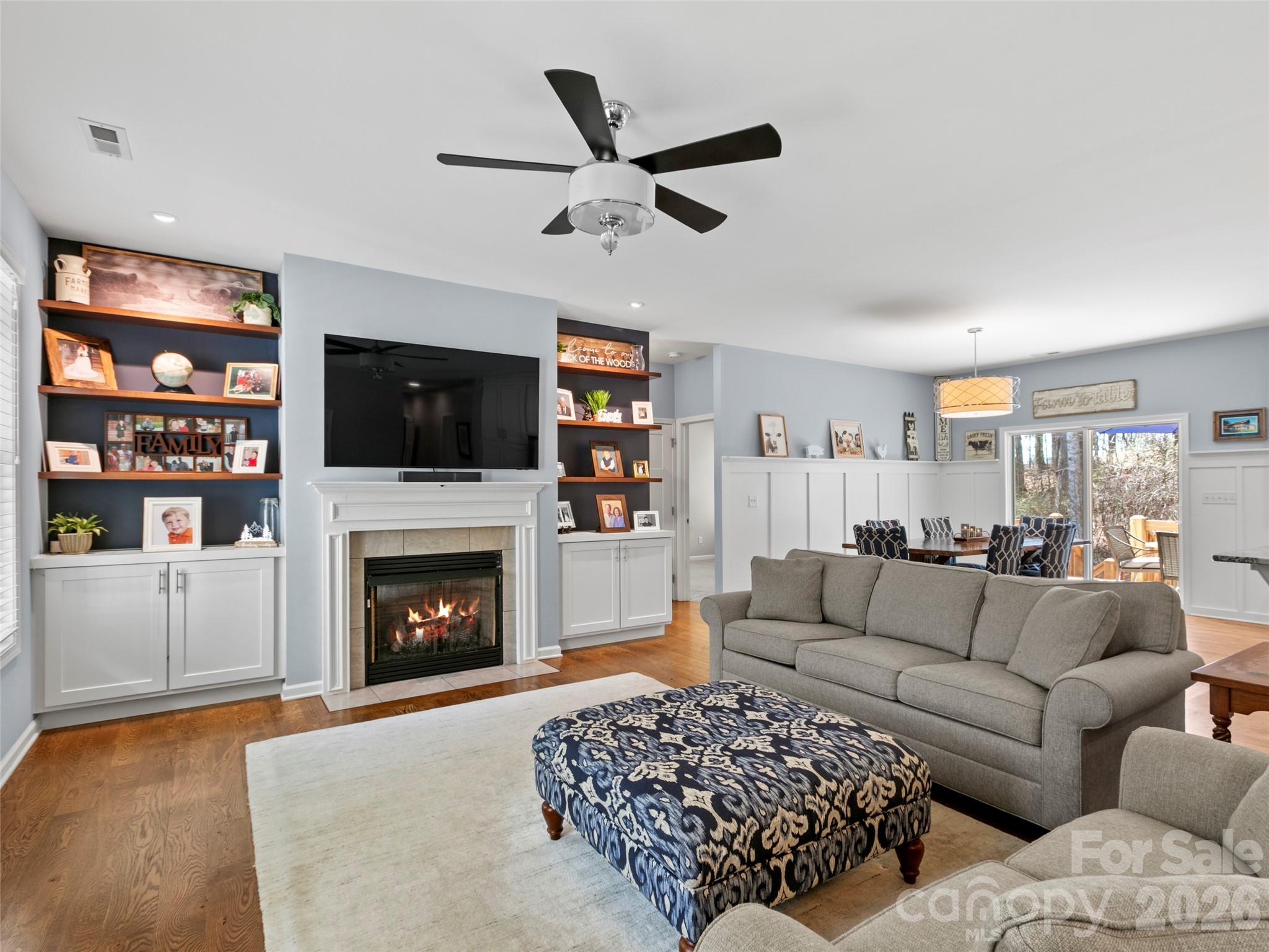 Open-concept main living area featuring seamless flow for everyday living and entertaining, highlighted by custom built-in shelving that adds both character and functional storage - 290 Sweetwater Hills Drive, Hendersonville