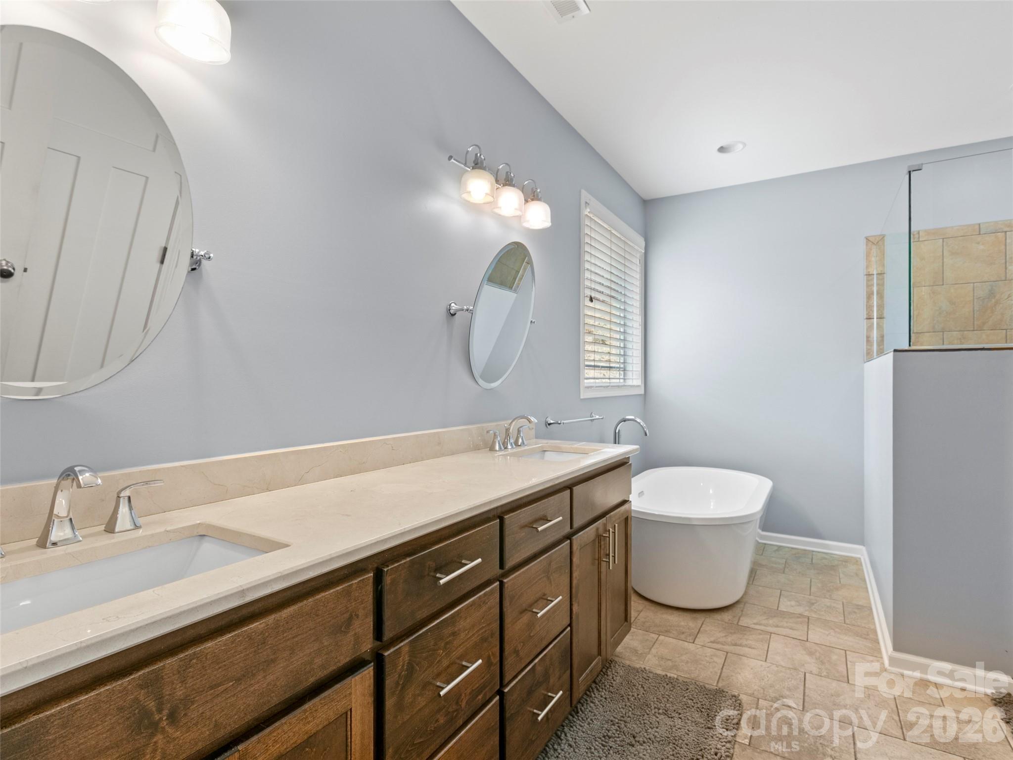 Luxurious primary bathroom offering a walk-in shower, soaking tub, private water room, and thoughtfully designed custom closet space - 290 Sweetwater Hills Drive, Hendersonville