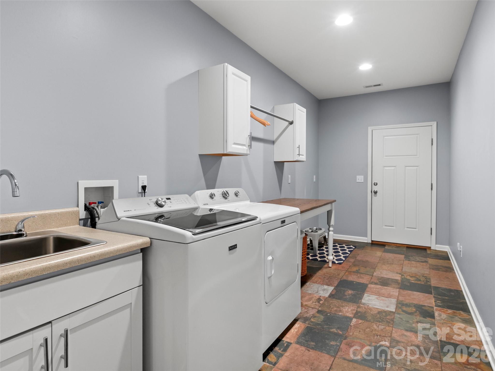 Well-designed mudroom offering laundry area with washer and dryer, convenient sink, and generous space for added functionality or customization - 290 Sweetwater Hills Drive, Hendersonville