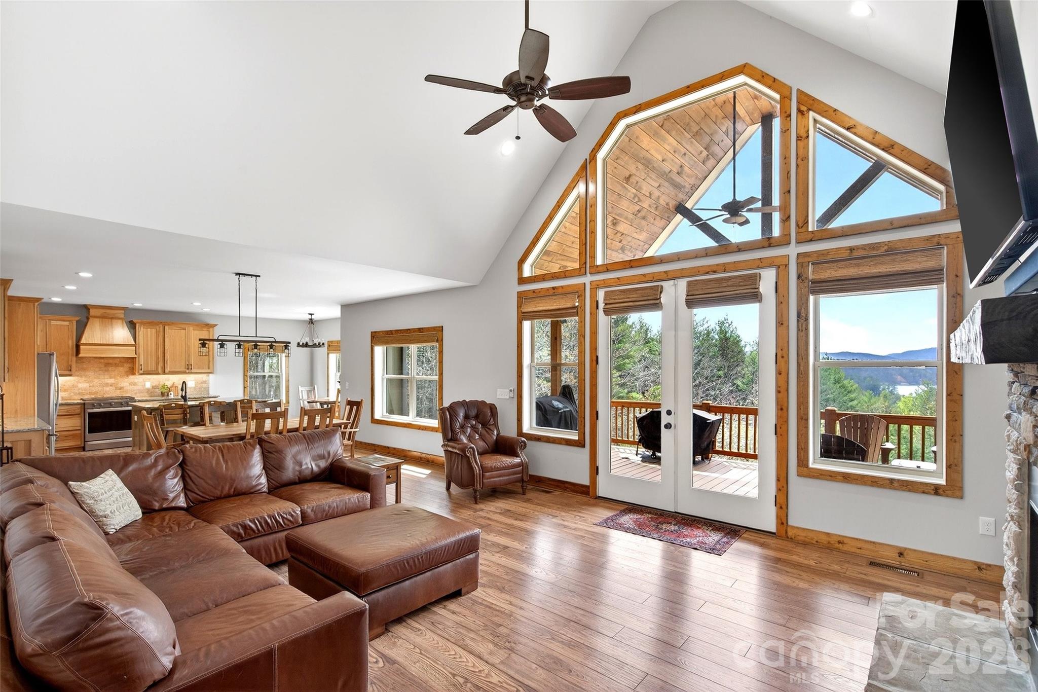 Great room with vaulted ceiling and a wall of windows framing the view - 207 Lake Crest Drive, Nebo