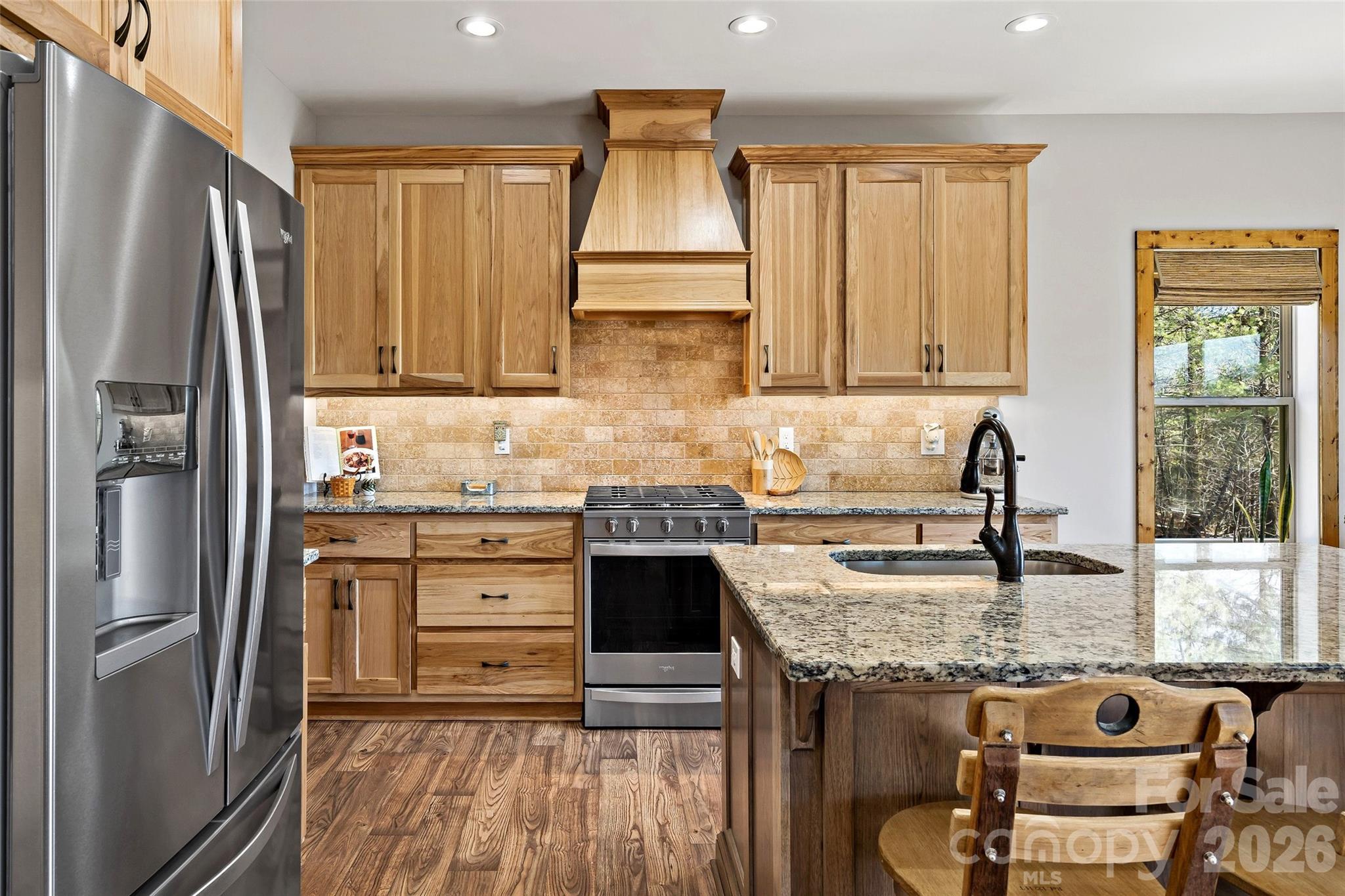 Kitchen with granite island, pro-style range and hood, open to dining and the view - 207 Lake Crest Drive, Nebo