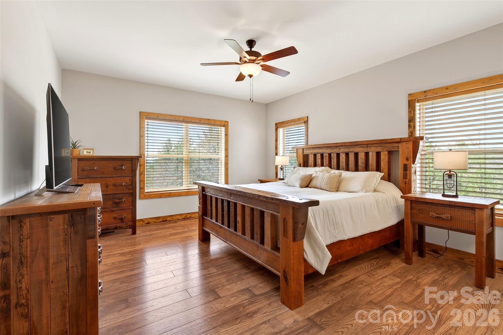 Main-level primary bedroom with hardwood floors and a mountain view from bed - 207 Lake Crest Drive, Nebo