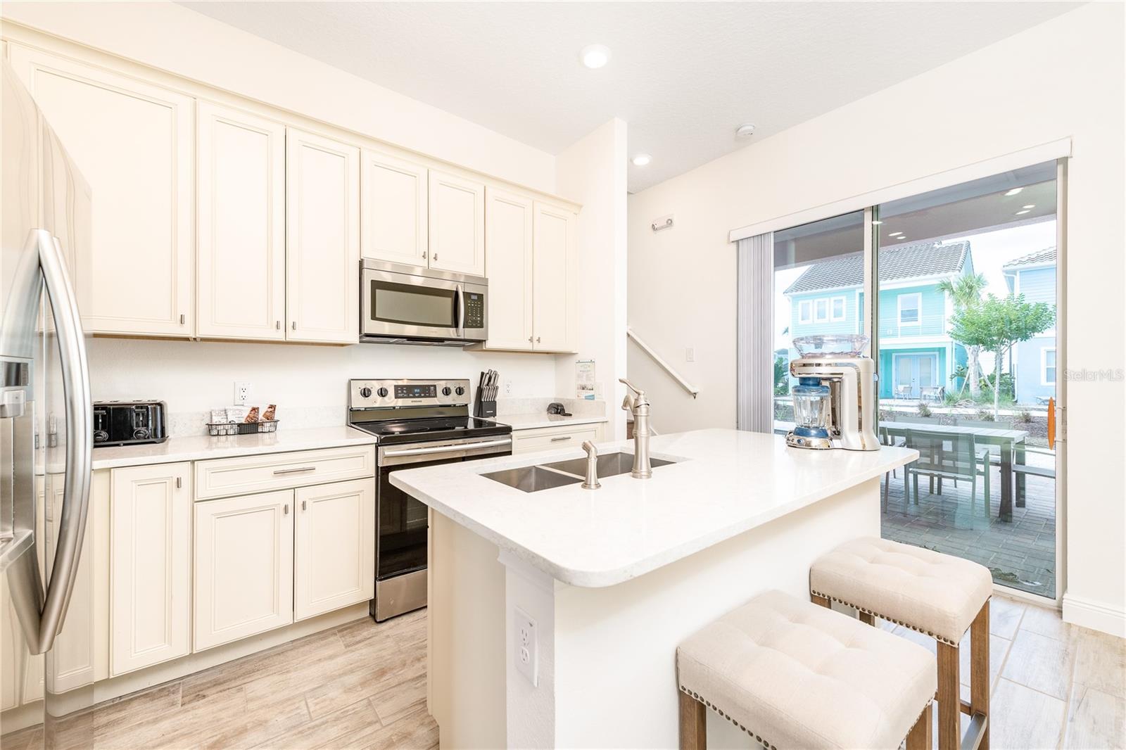 Open concept kitchen with quartz countertops and stainless steel appliances in Margaritaville Resort Orlando - 8075 KNEE DEEP RD, KISSIMMEE
