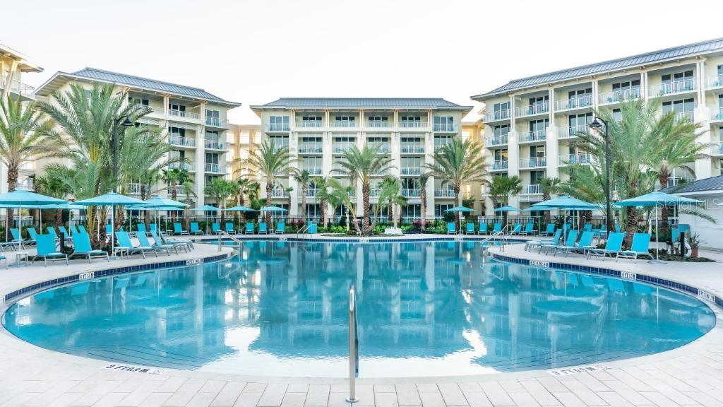 Large resort pool surrounded by tropical landscaping in Kissimmee Florida - 8075 KNEE DEEP RD, KISSIMMEE