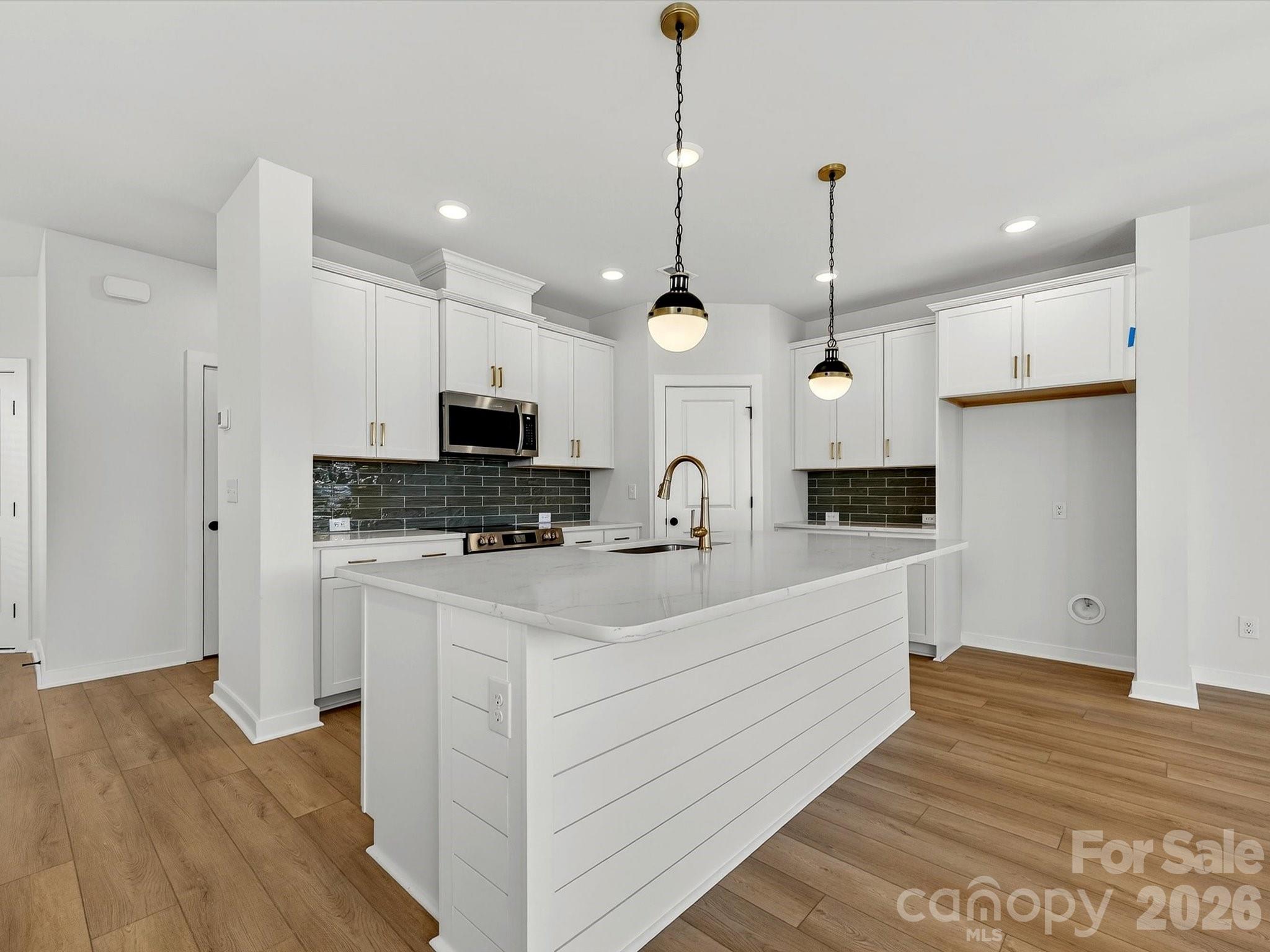 42" white cabinets with soft close doors & drawers. Quartz Countertops, large Island with shiplap. Large corner pantry with solid shelving. Frigidaire gallery appliances. LVP flooring throughout the main floor. - 202 Quartz Hill Way, Waxhaw