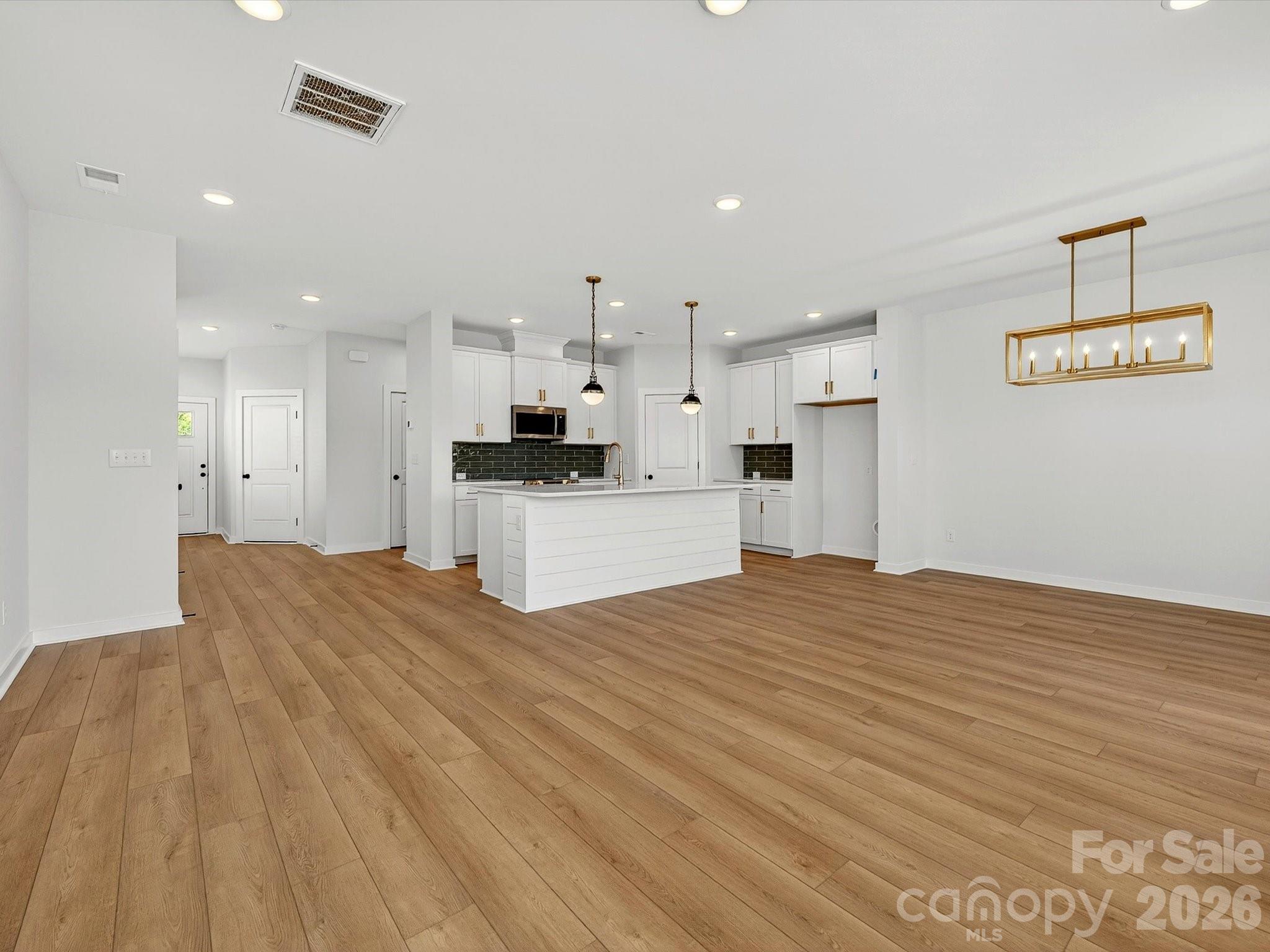 42" white cabinets with soft close doors & drawers. Quartz Countertops, large Island with shiplap. Large corner pantry with solid shelving. Frigidaire gallery appliances. LVP flooring throughout the main floor. - 202 Quartz Hill Way, Waxhaw