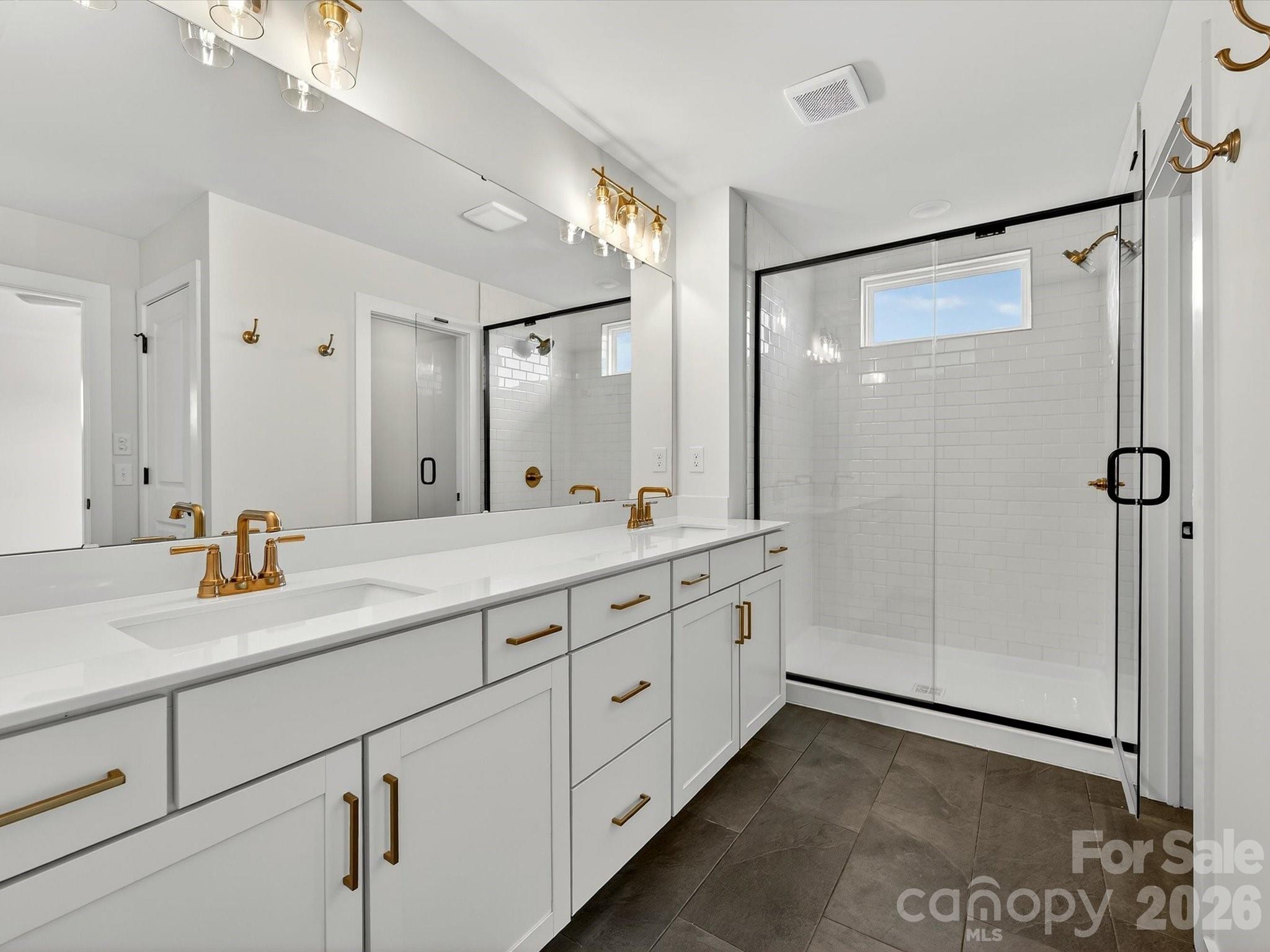 Primary bath with large, tiled shower, large dual vanity with quartz countertops. Tiled floor. Separate toilet in closet - 202 Quartz Hill Way, Waxhaw