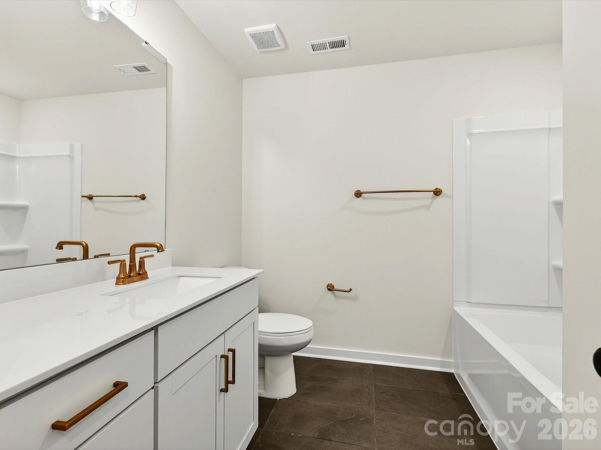 Hall bath with tiled floor, vanity with soft close doors & drawers, quartz countertops & linen closet - 202 Quartz Hill Way, Waxhaw