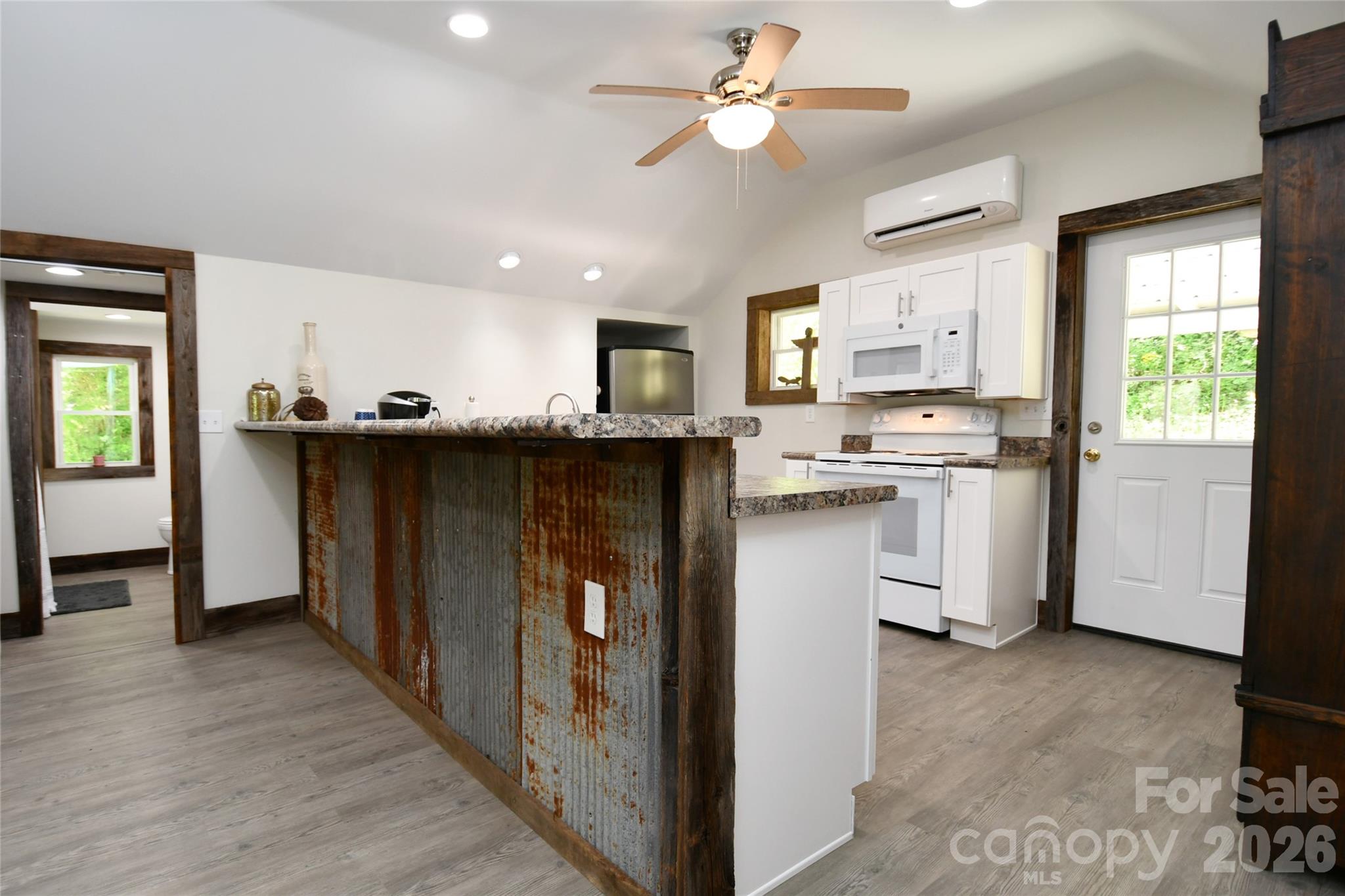 The kitchen is separated from the living room by a breakfast bar accented with repurposed barn roofing - 2180 Pigeon Roost Road, Green Mountain