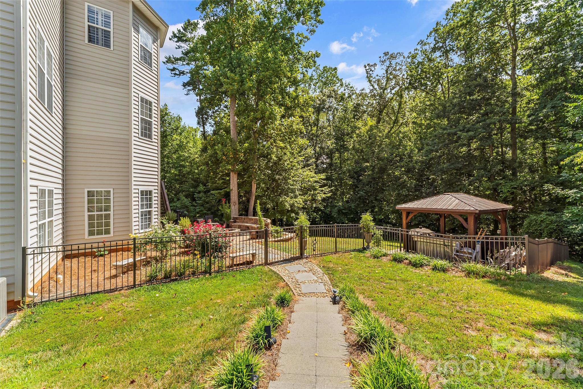 The yard has a gentle slope, but stairs leading from the driveway to the backyard make it accessible and easy. - 120 Harrison Point Court, Mooresville