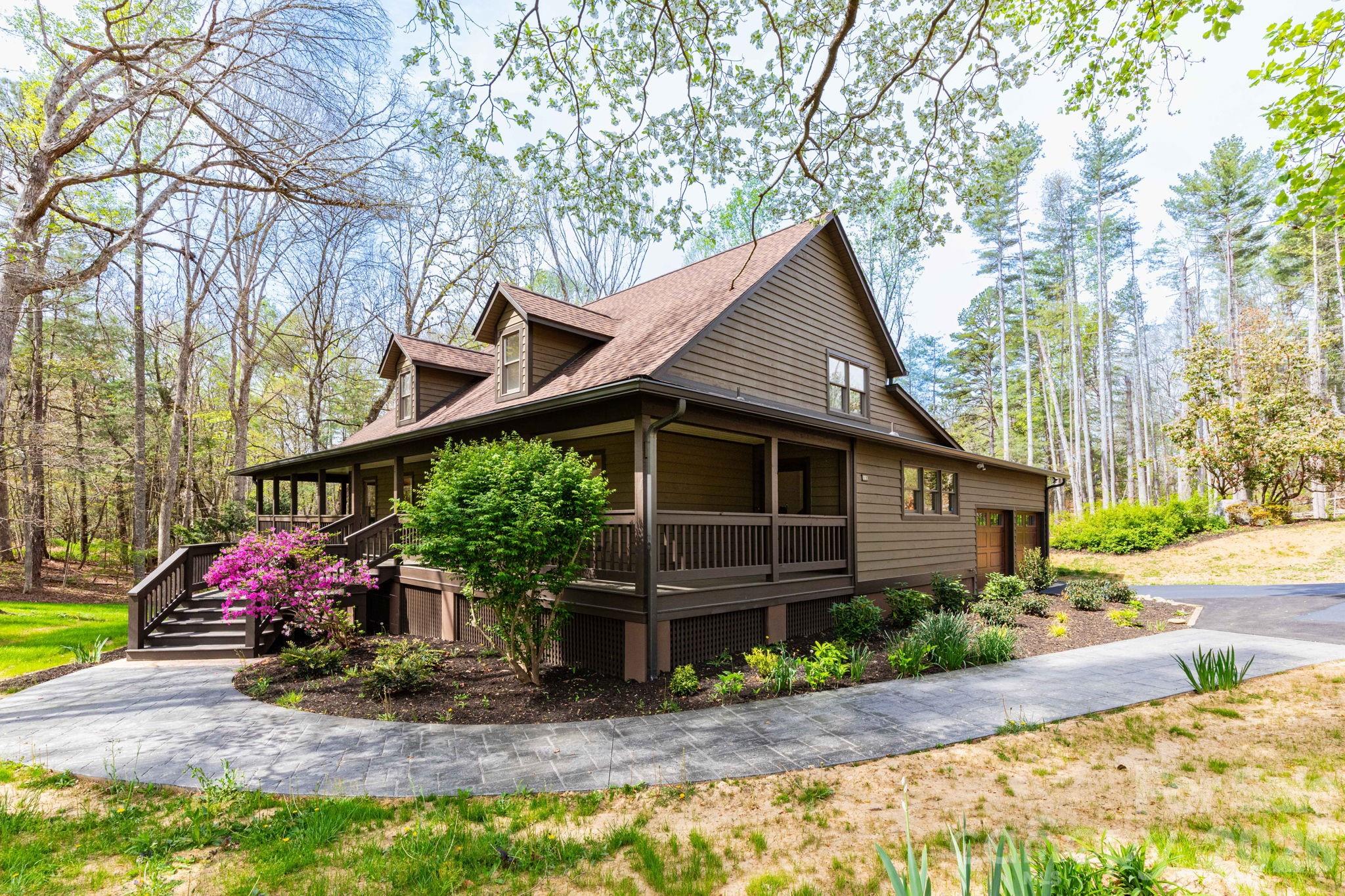 Side view showcasing the home's natural setting and well-maintained landscaping, blending seamlessly into the surrounding woods. - 68 Sigmon Road, Fletcher