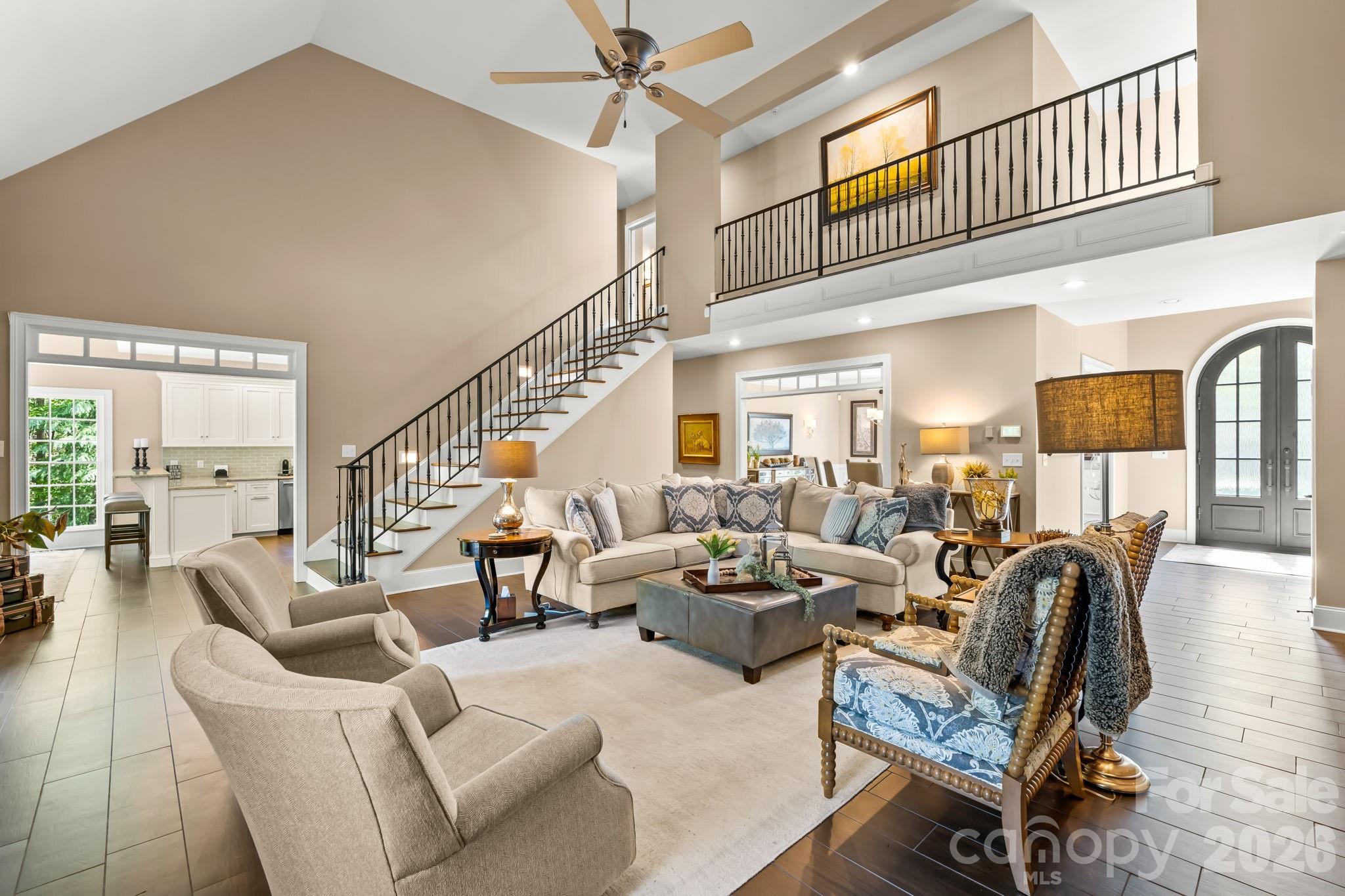 Soaring vaulted ceilings and oversized windows with a custom iron railing to the open 2nd floor balcony - 11555 Double Spring Road, Lewisville