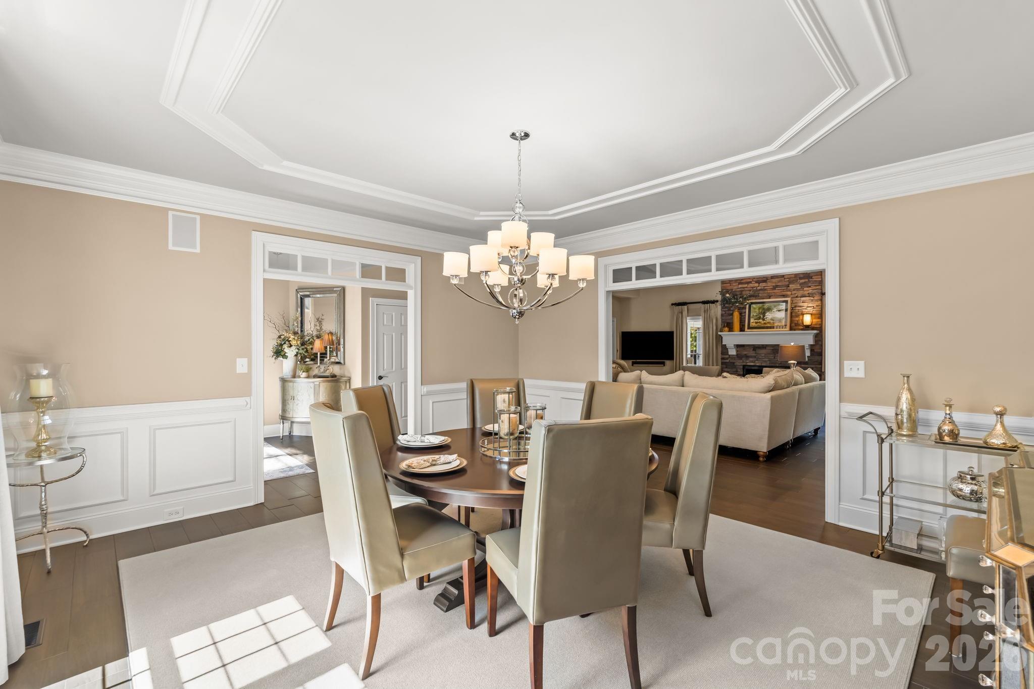 Every guest has a view when entertaining in this lovely dining room with wainscoting and oversized passthroughs - 11555 Double Spring Road, Lewisville