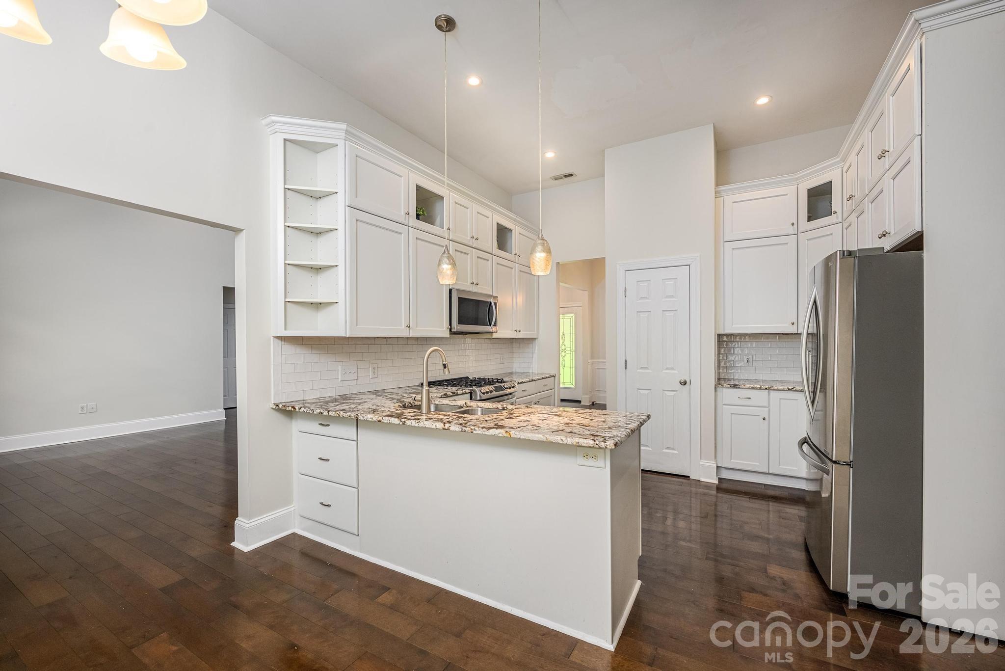 Kitchen w/Stainless Appliances & Tile Backsplash - 7867 Golf Course Drive N, Denver