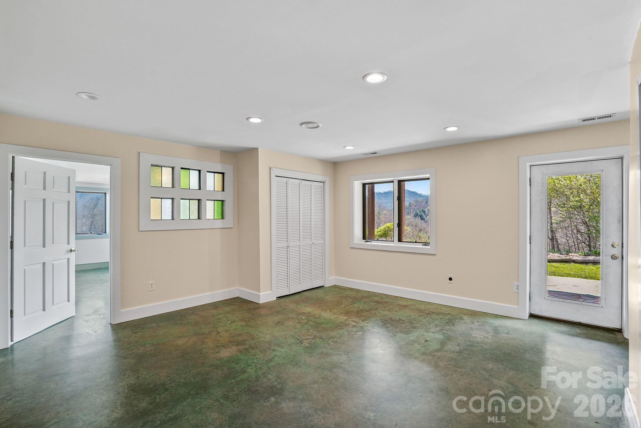 Basement family room w/entry to patio and gorgeous custom stained concrete floors - 310 Burr Ridge, Marshall