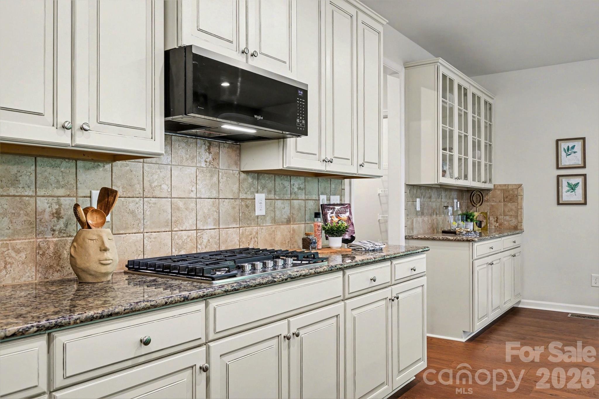 Enjoy cooking on the five-burner gas stove top, or the convenience of the microwave above. - 824 Abbeywood Drive, Waxhaw
