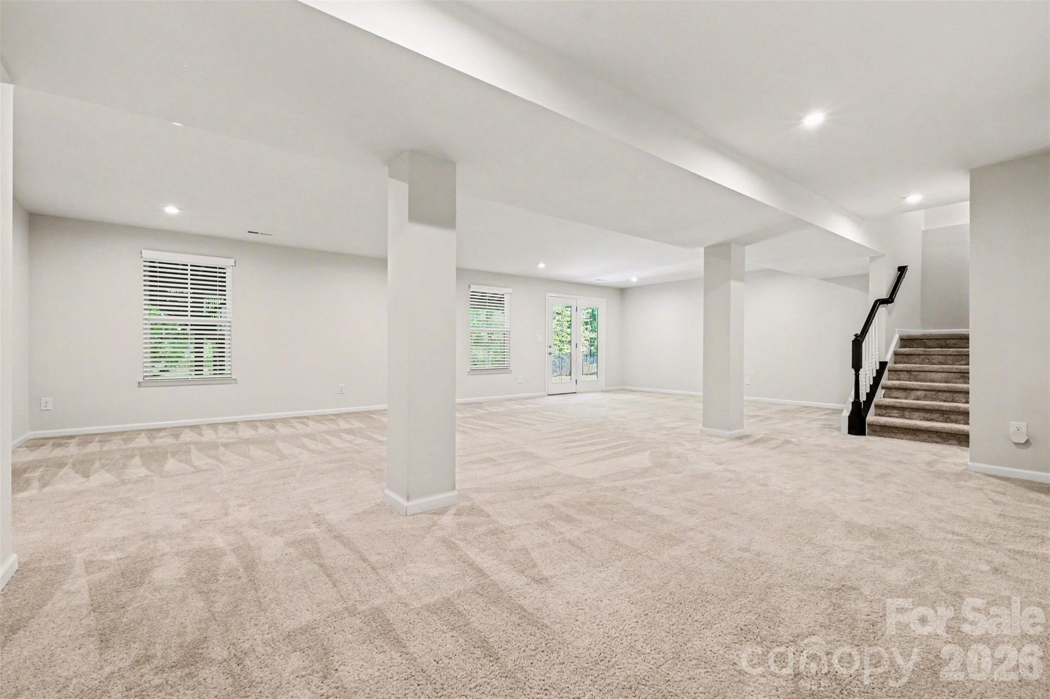 Lower level entertainment space with doors that open to the patio and fire-pit. - 824 Abbeywood Drive, Waxhaw