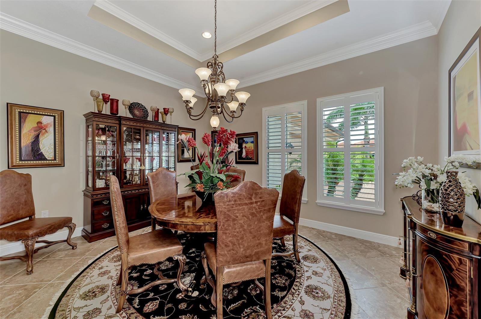 The dining room features plantation shutters, double crown molding, and large open dining. - 10965 BULLRUSH DR, VENICE