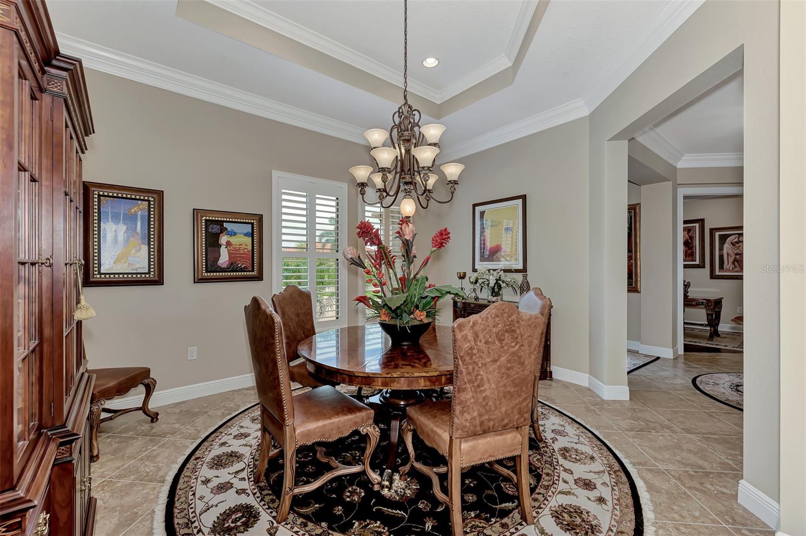 The dining room features plantation shutters, double crown molding, and large open dining. - 10965 BULLRUSH DR, VENICE