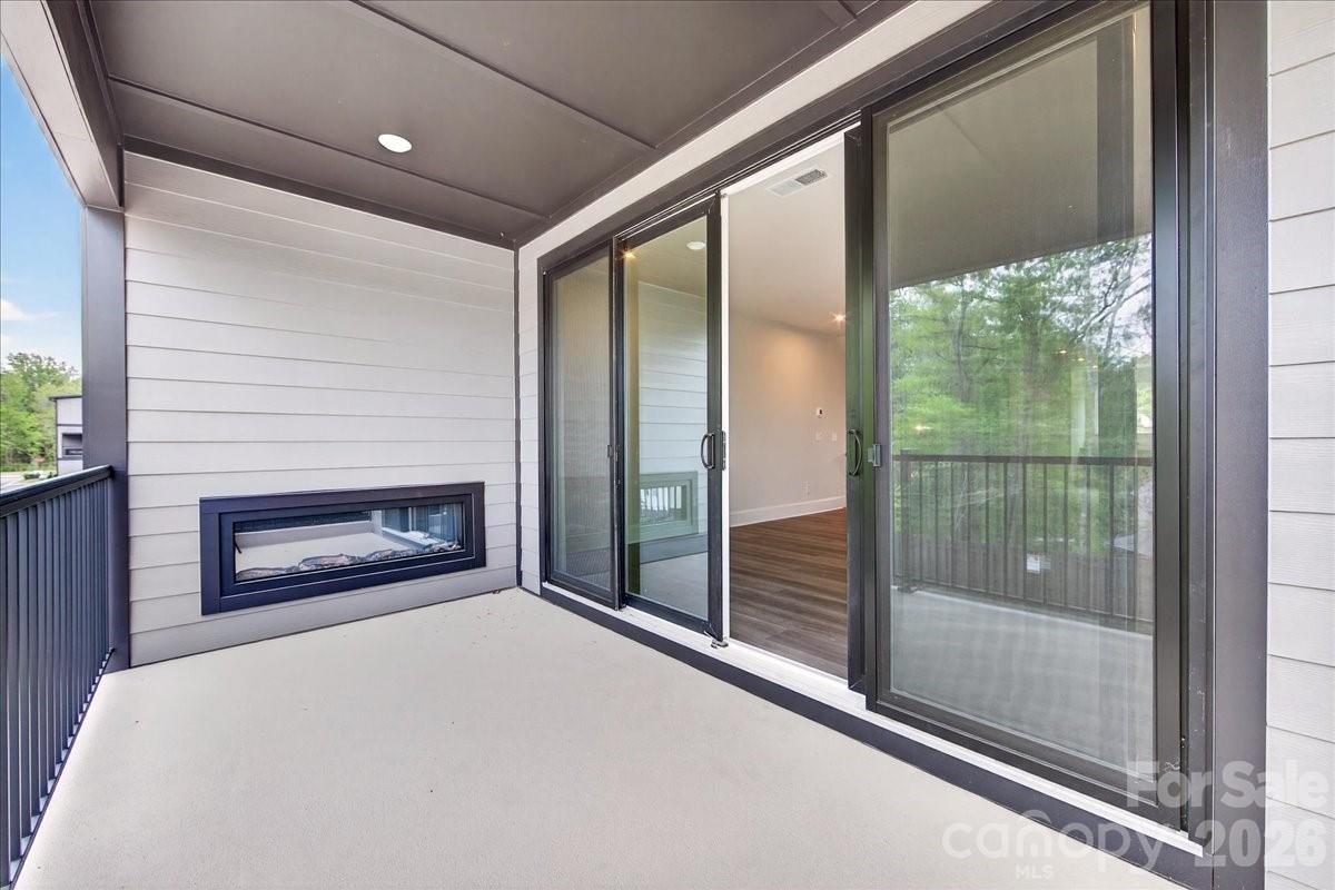 Covered outdoor living space with an electric fireplace - 420 Old Town Village Road, Waxhaw