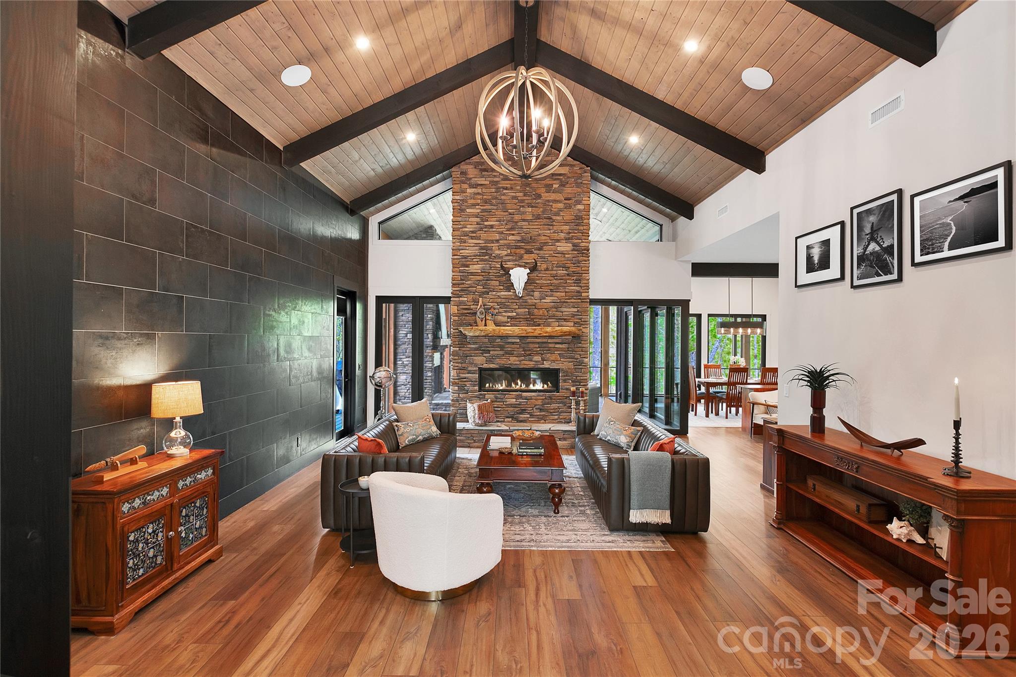 Welcoming grand entrance leads to a beautiful gathering space featuring a stacked stone fireplace and rich wood vaulted ceilings above. - 726 Ugugu Drive, Brevard