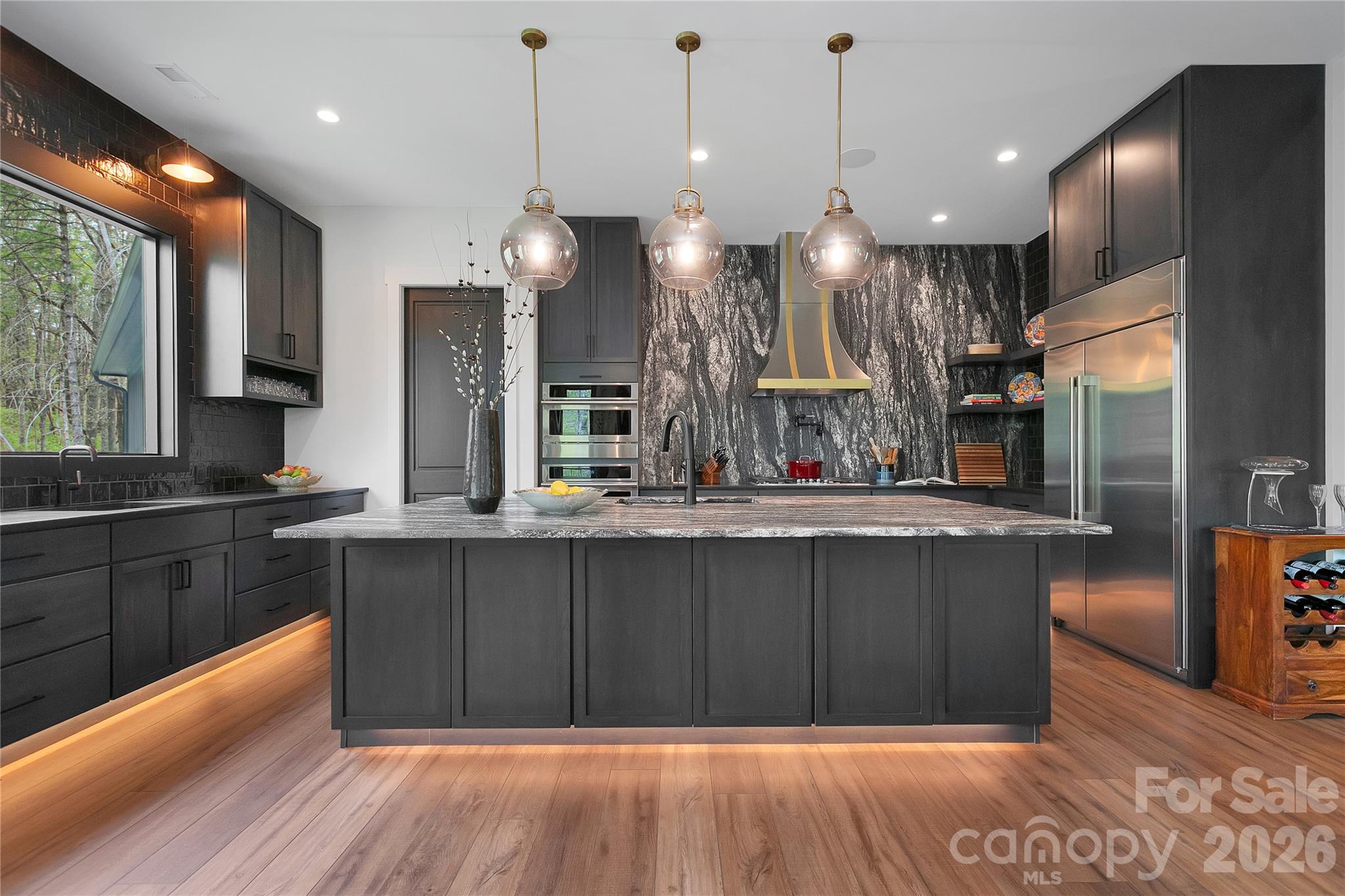 Thoughtfully designed for the culinary enthusiast, the kitchen offers abundant counter space and functions as a natural gathering hub, enhanced by under cabinet floor lighting that creates a soft, inviting ambiance. - 726 Ugugu Drive, Brevard