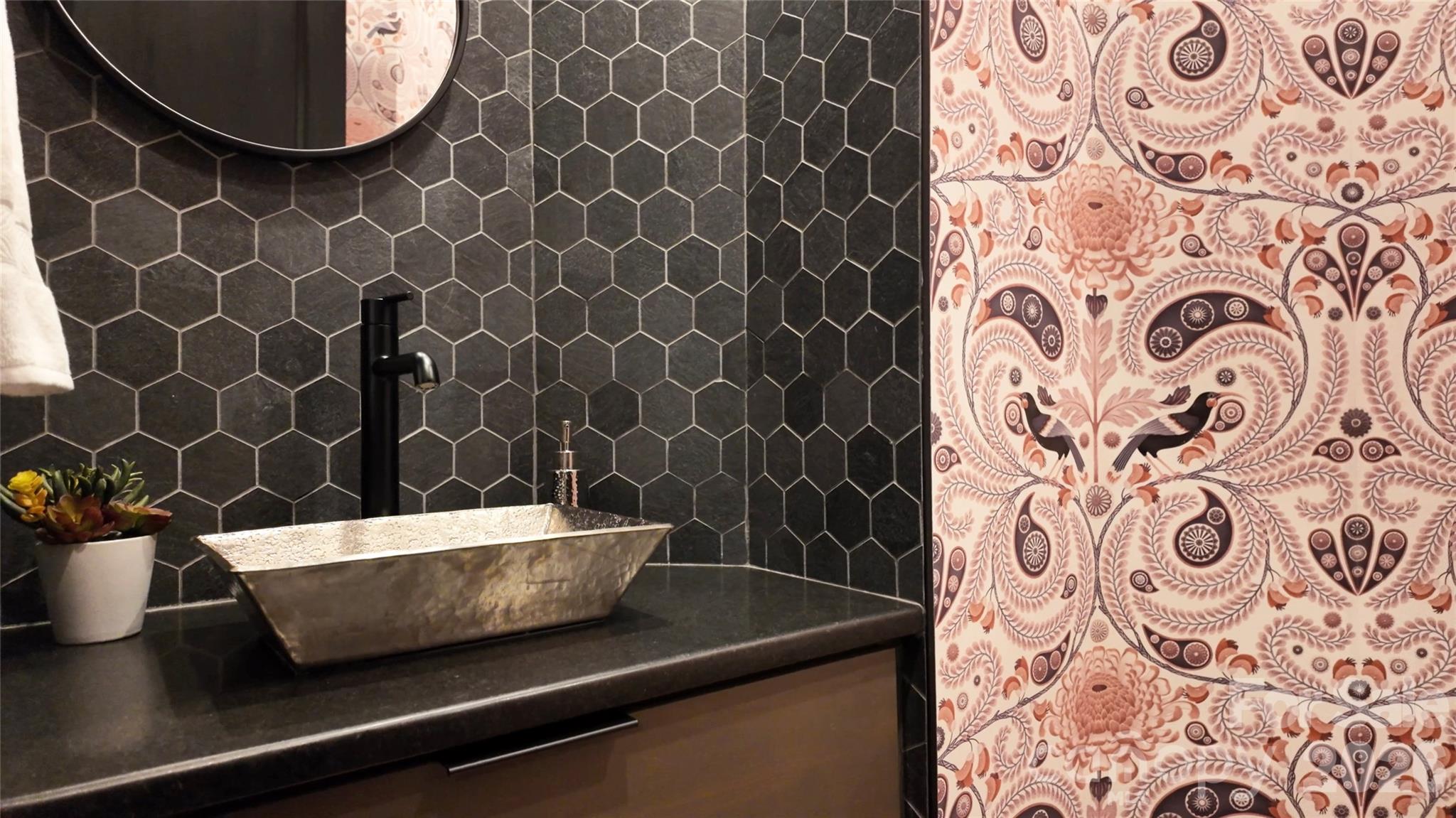 Main level guest half bath features sophistcated finishes, complemented by stylish wallpaper that brings fun, and unexpected flair. - 726 Ugugu Drive, Brevard
