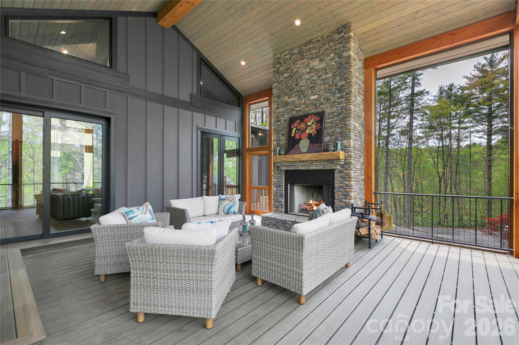 The screen porch serves as a peacful retreat, highlighted by a stacked stone wood burning fireplace that sets the tone for cozy evenings. - 726 Ugugu Drive, Brevard
