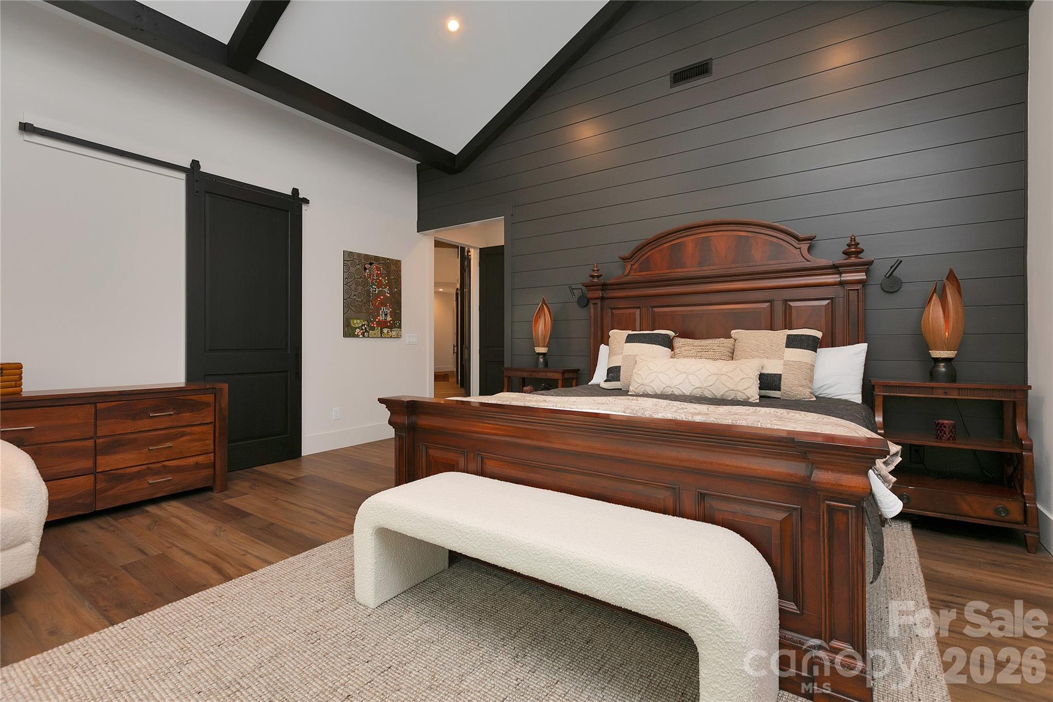 Designed for comfort and visual impact, the primary suite showcases soaring ceilings with striking exposed wood beams. - 726 Ugugu Drive, Brevard