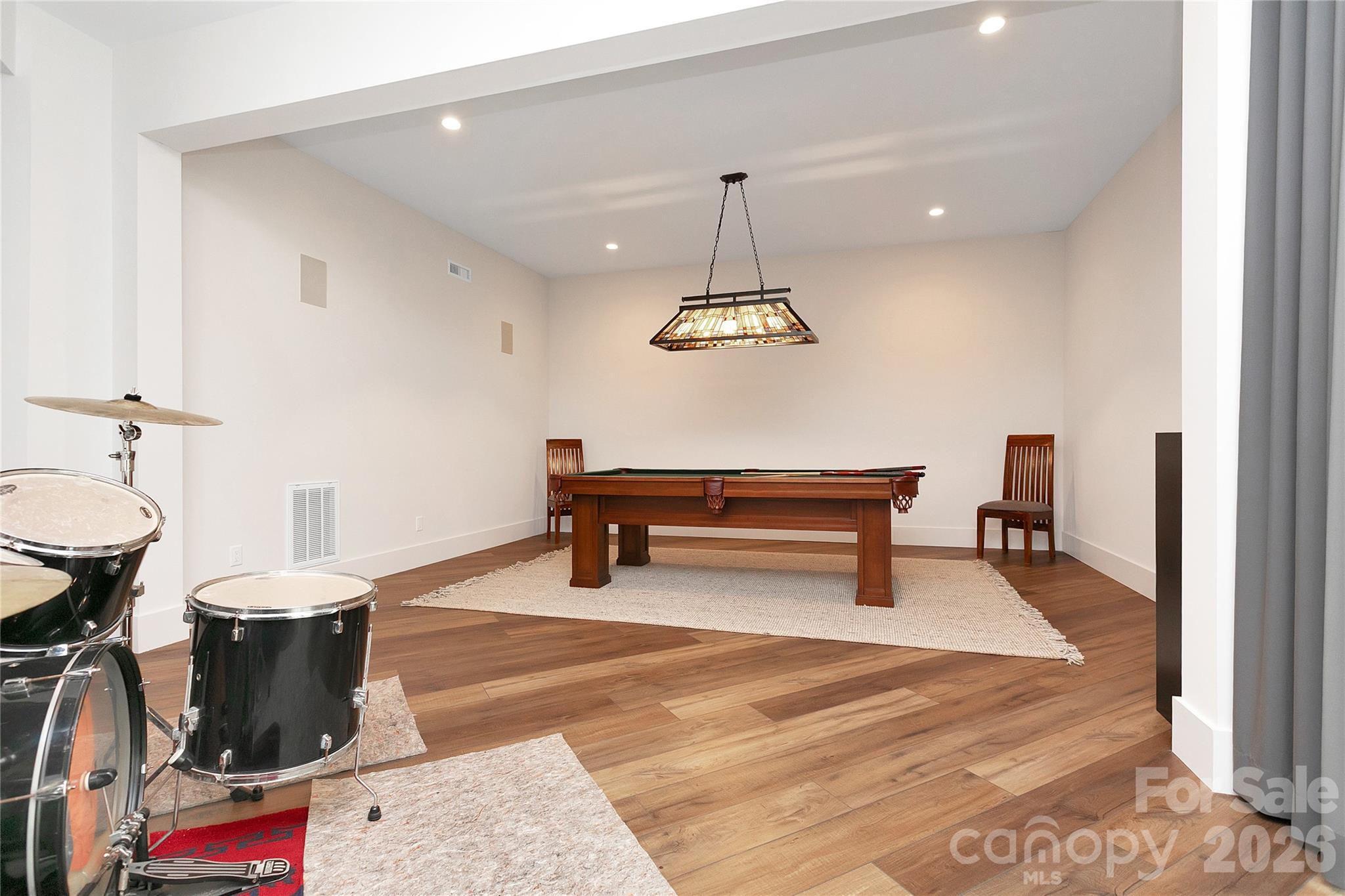 Lower level includes a dedicated game room with a pool table, providing a comfortable and casual space for recreation and downtime. - 726 Ugugu Drive, Brevard