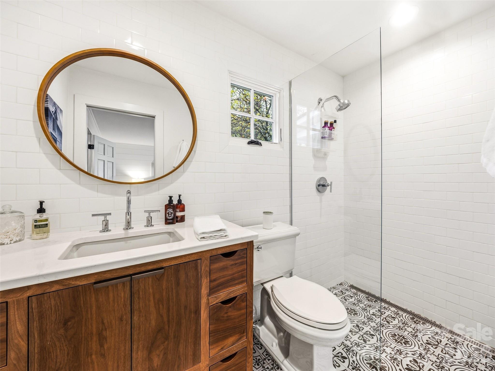 Beautiful full bathroom featuring a curbless walk-in shower and custom built vanity. - 10 Kalimar Heights, Hendersonville