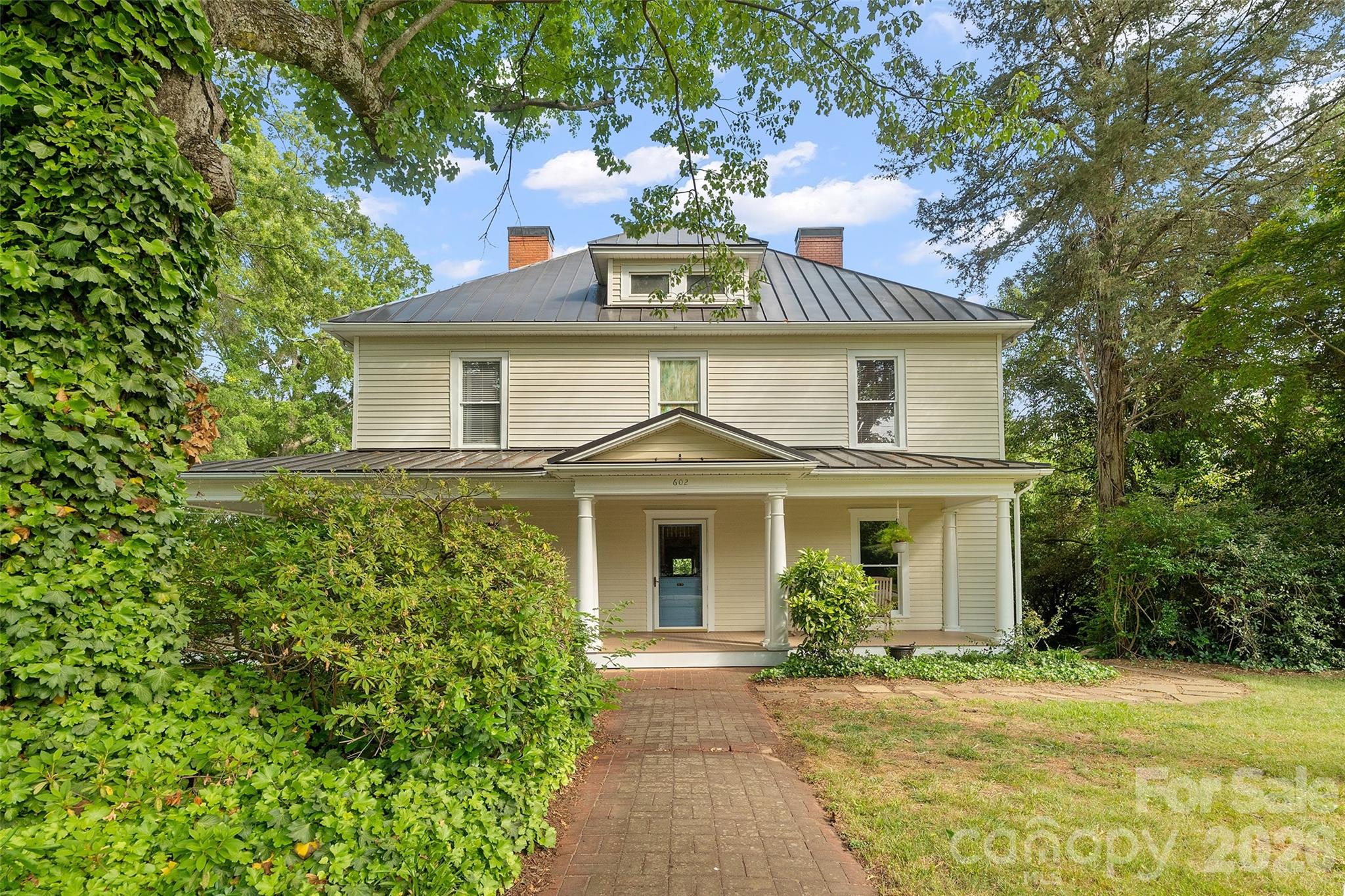 Timeless two-story Colonial Revival featuring a wraparound porch with classical columns and a pedimented entry. Ideally located just steps from Davidson College and all that downtown Davidson has to offer. - 602 N Main Street, Davidson