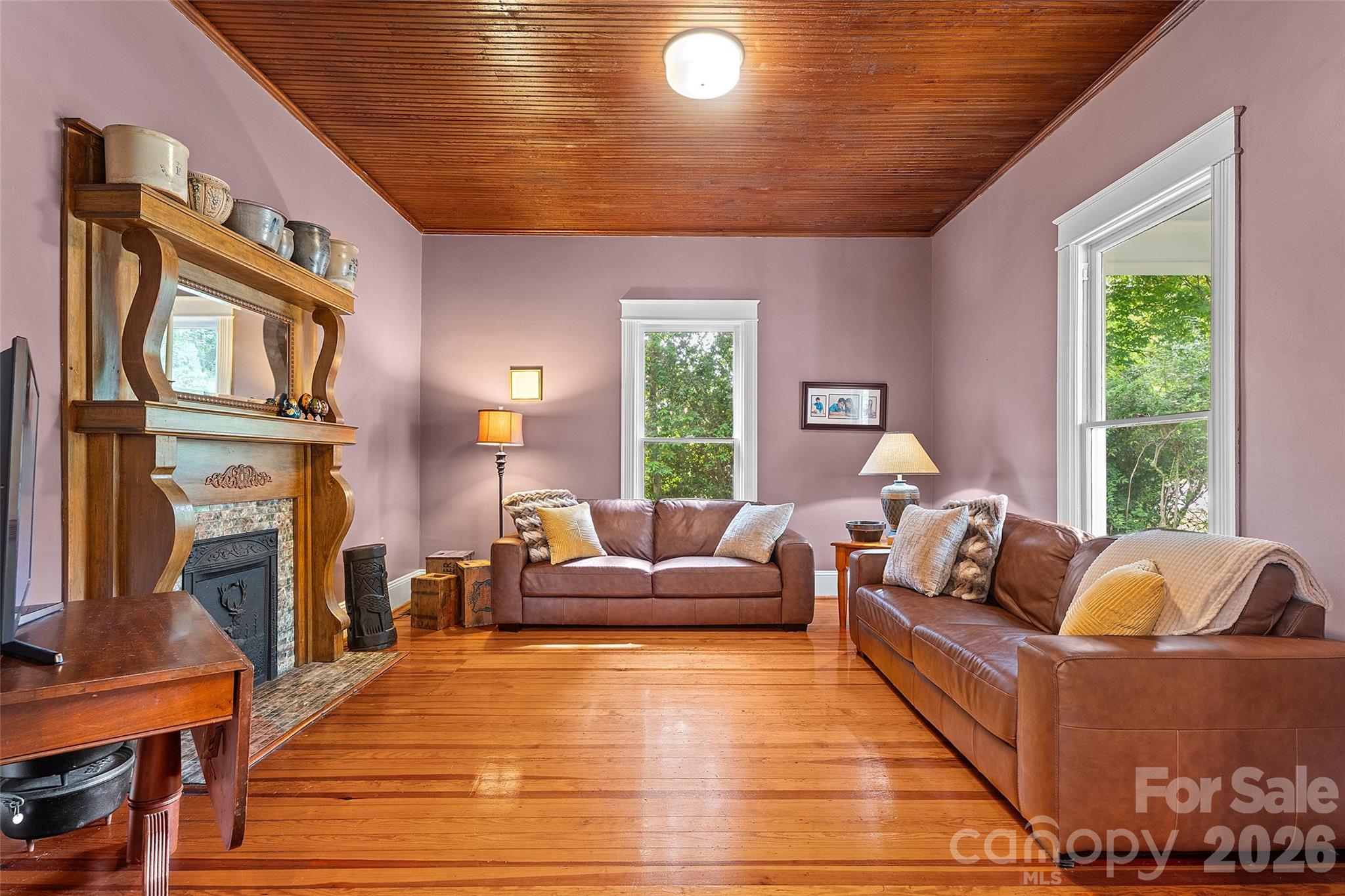 Quaint family room with wood mantel with elegant curved detailing, complemented by a classic tiled surround and decorative cast iron insert—adding timeless character and warmth to the space. - 602 N Main Street, Davidson