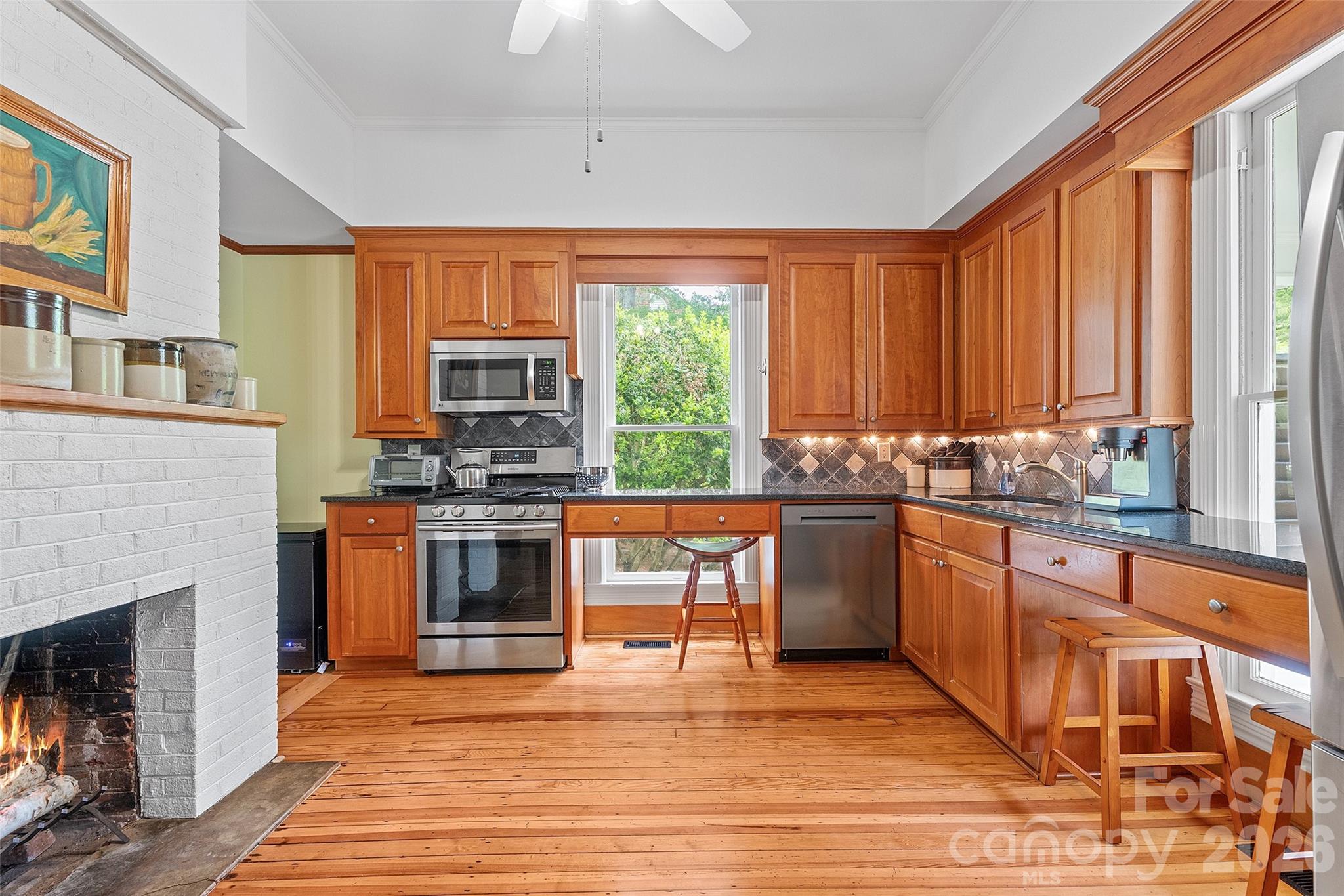 The classically updated kitchen offers high-quality wood cabinetry, granite countertops, and a design that honors the home’s history while supporting modern use. - 602 N Main Street, Davidson