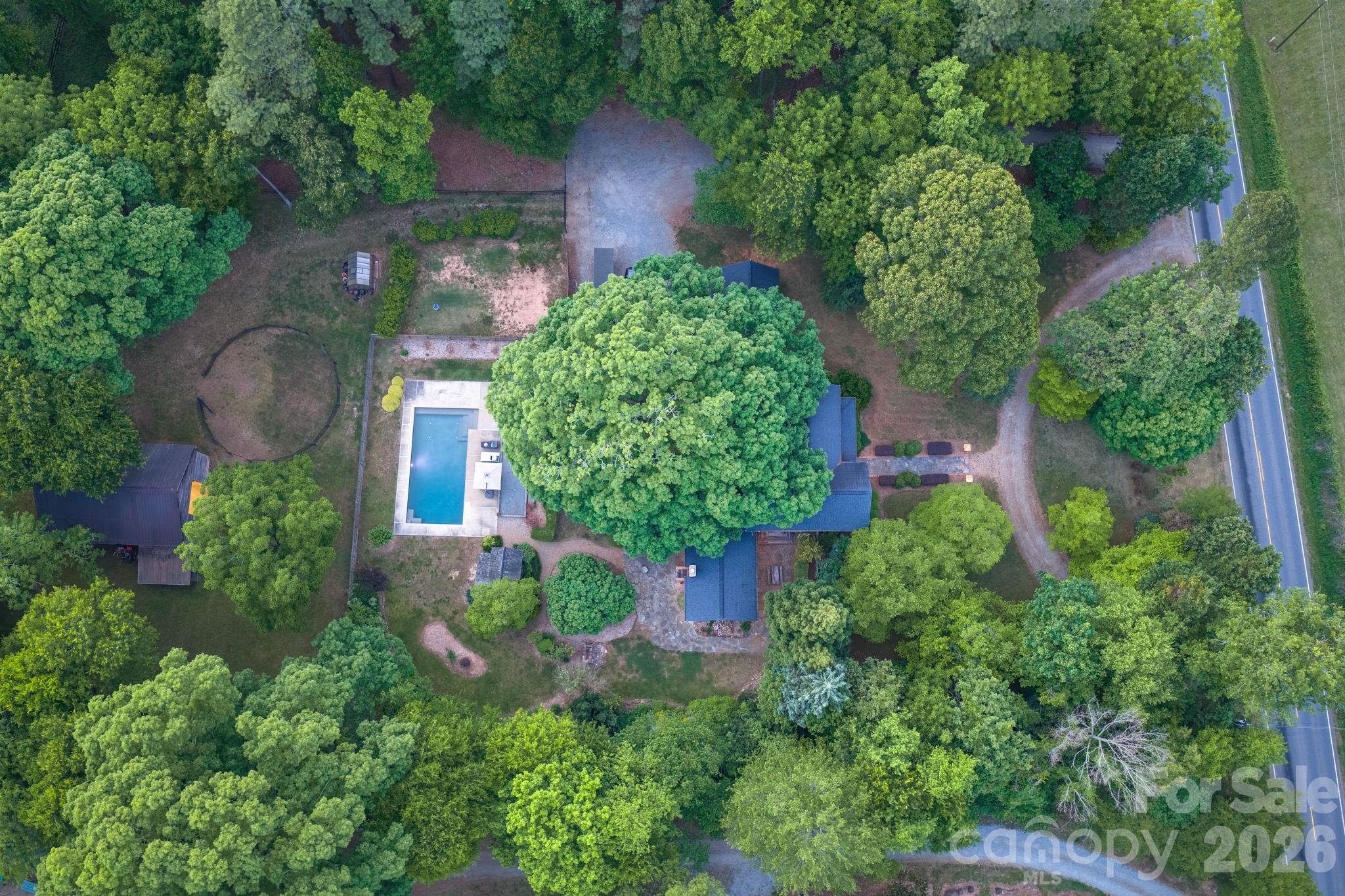 The tree canopy and landscaping provide a cool and private retreat around the home. - 10915 Beatties Ford Road, Huntersville