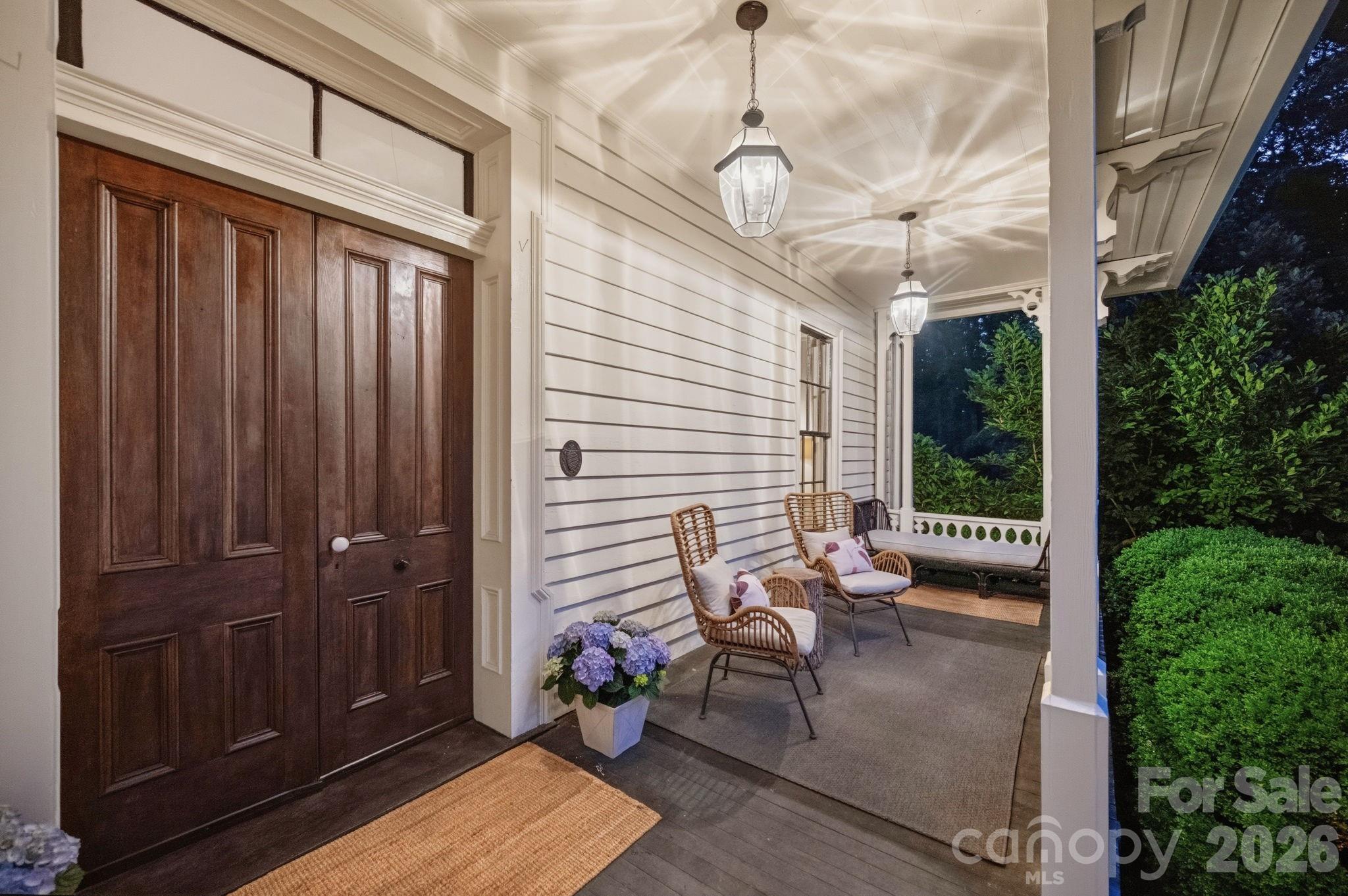 Restored front porch still maintains the Victorian decorative wood work. Original solid wood double front doors w/antique hardware and transom windows - 10915 Beatties Ford Road, Huntersville