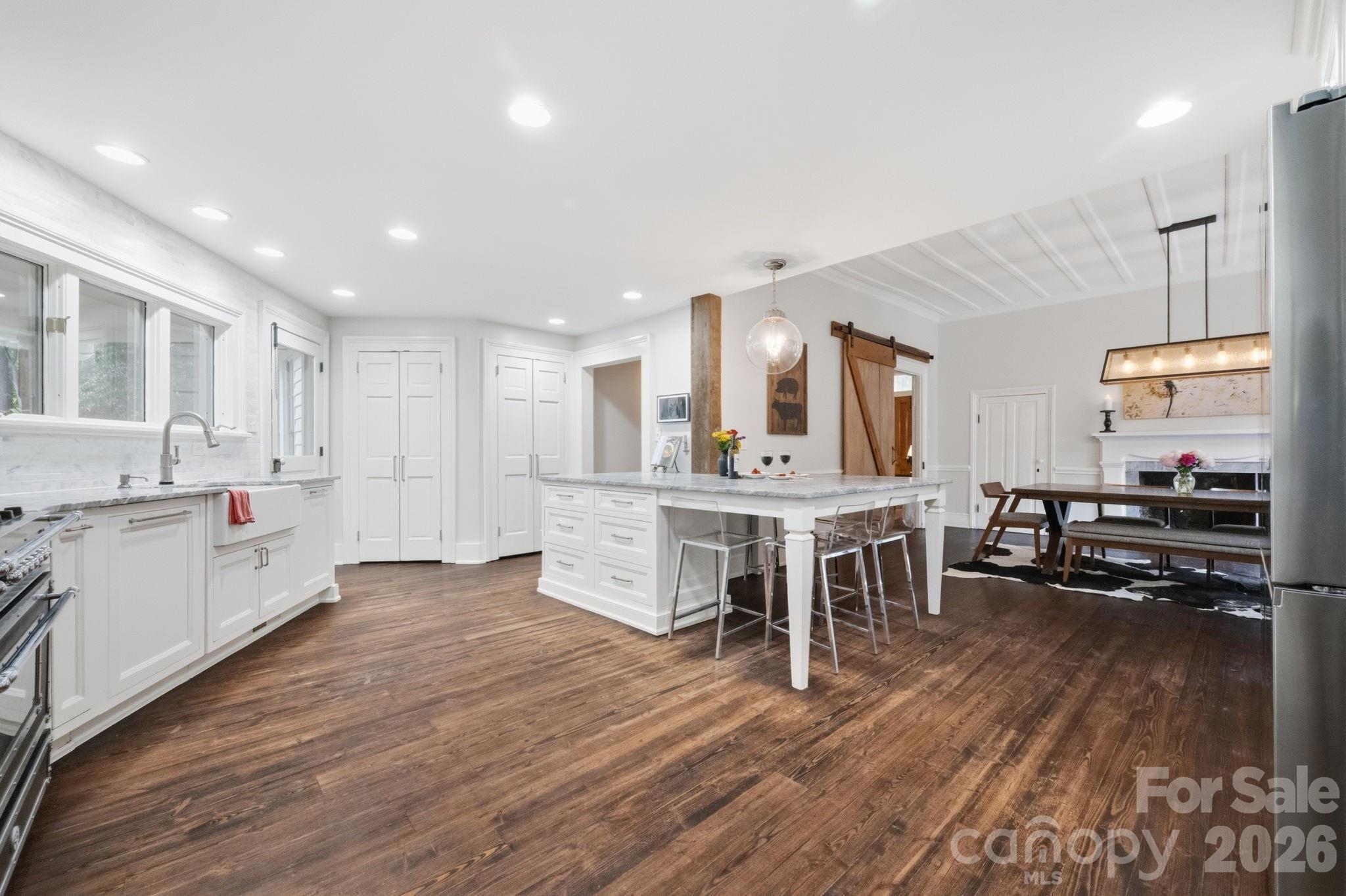 Newly renovated kitchen with honed marble countertops, inset custom cabinetry, top of the line appliances including an Italian Bertazonni Gas Range and matching exhaust hood - 10915 Beatties Ford Road, Huntersville