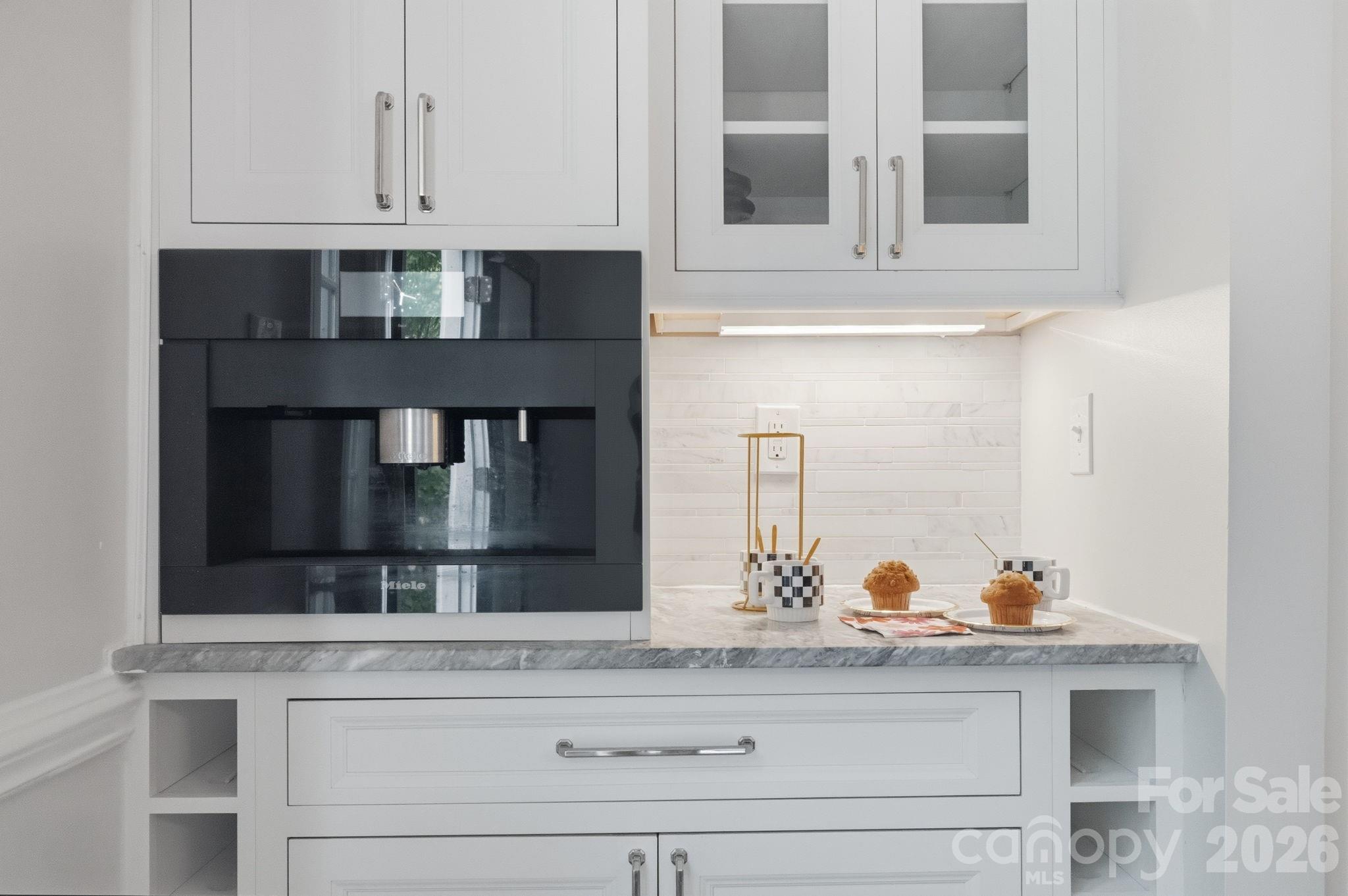 Built-in coffee and wine bar with Miele coffee maker, marble countertop, glass display cabinets and wine bottle cubbies - 10915 Beatties Ford Road, Huntersville