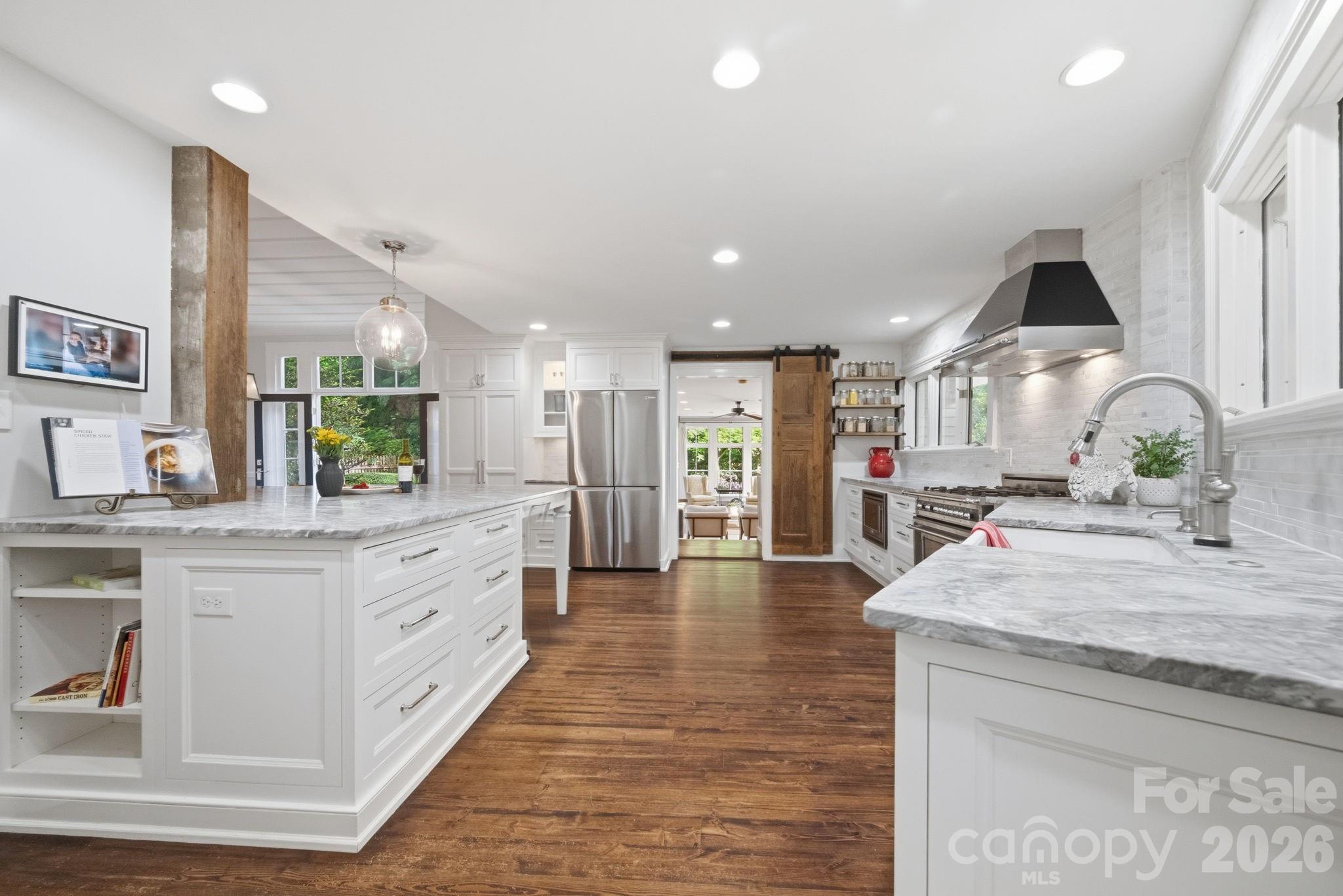 Step down to the great room through the barn door. - 10915 Beatties Ford Road, Huntersville